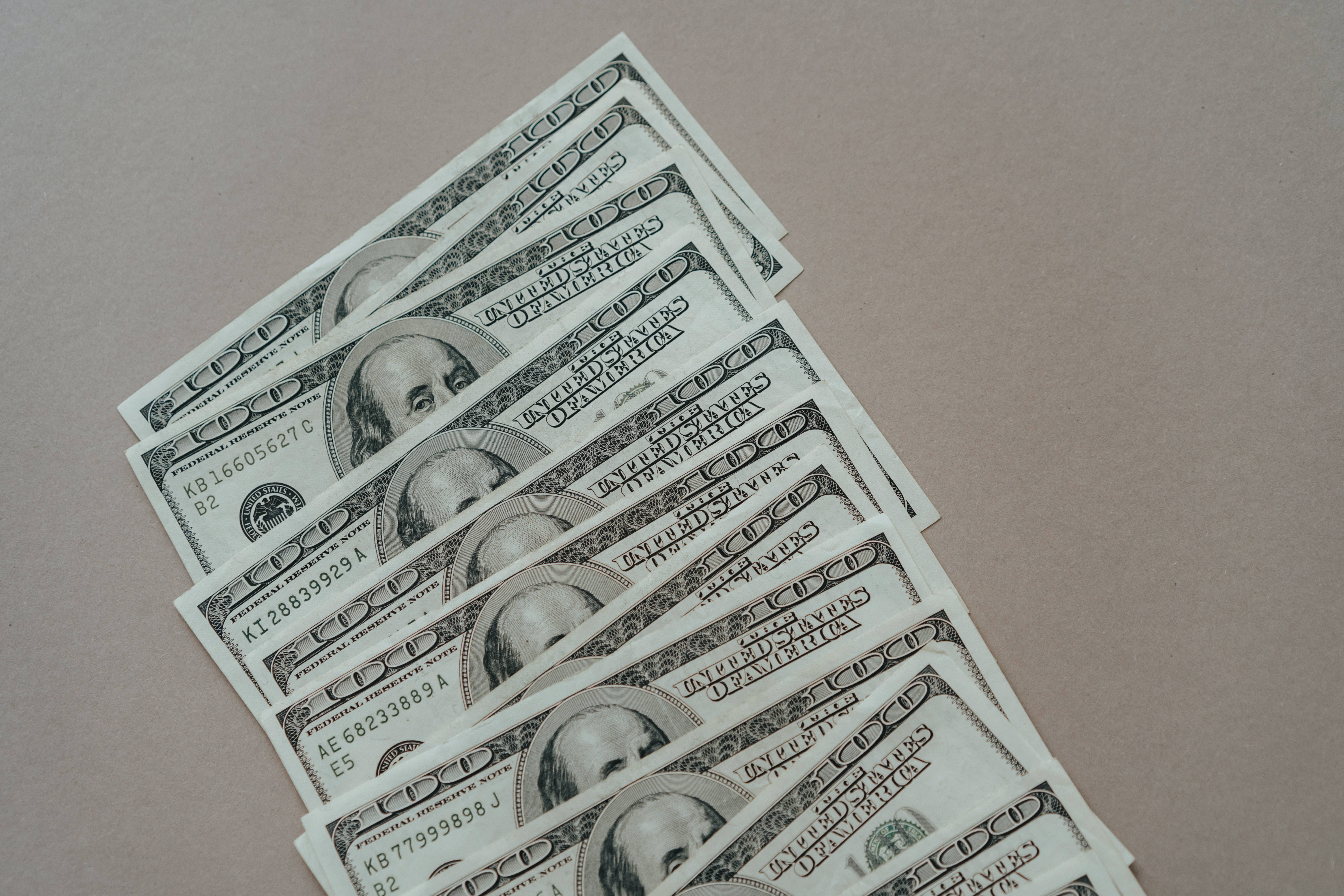 one hundred dollar bills, crisp, neutral beige surface, 5K Desktop Wallpaper