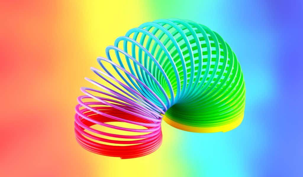 rainbow-colored coiled spring toy, vibrant gradient background, tropical beach, SD Desktop Wallpaper
