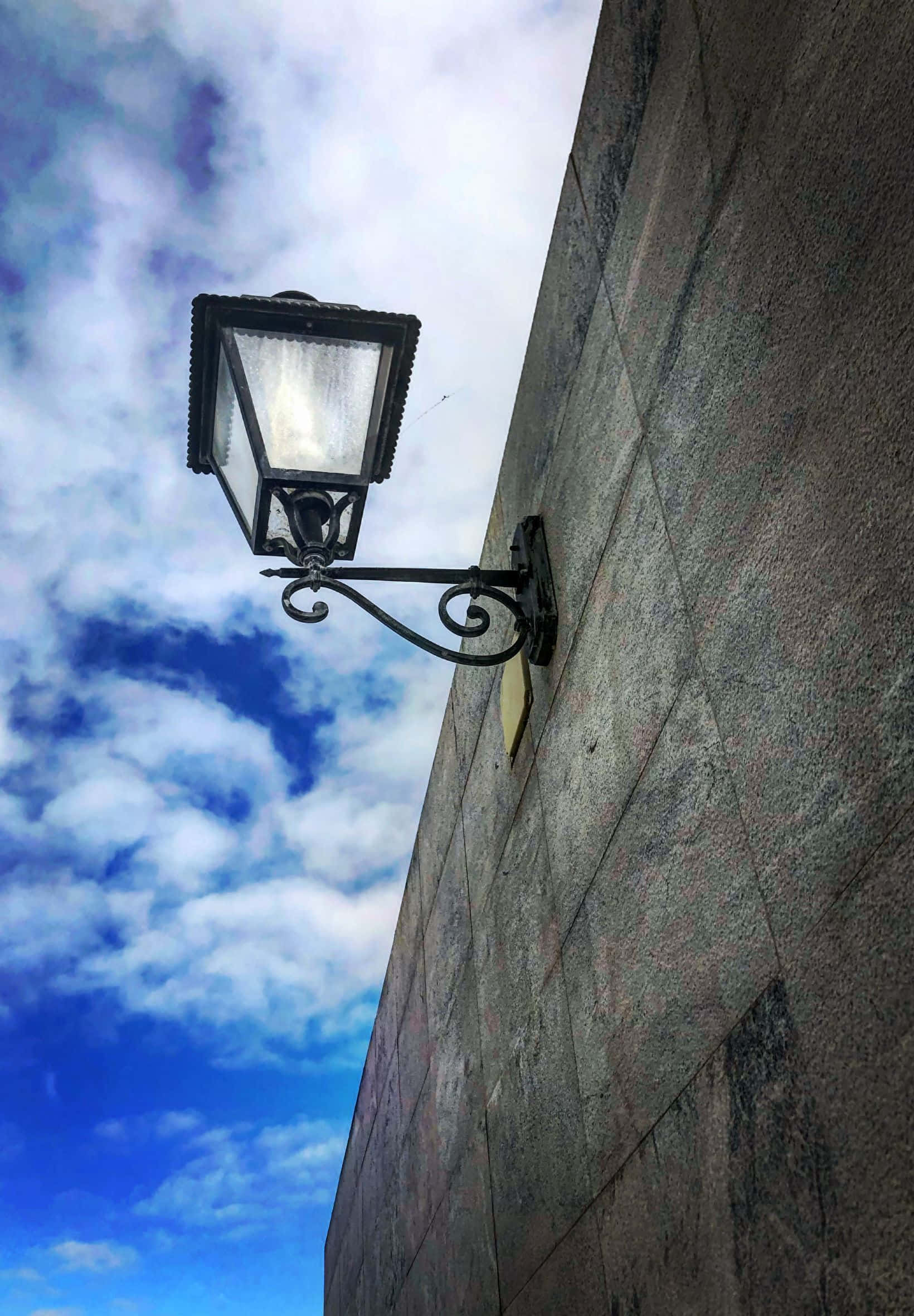 vintage black wrought iron street lamp, stone wall, vibrant blue sky, Full HD Phone Wallpaper