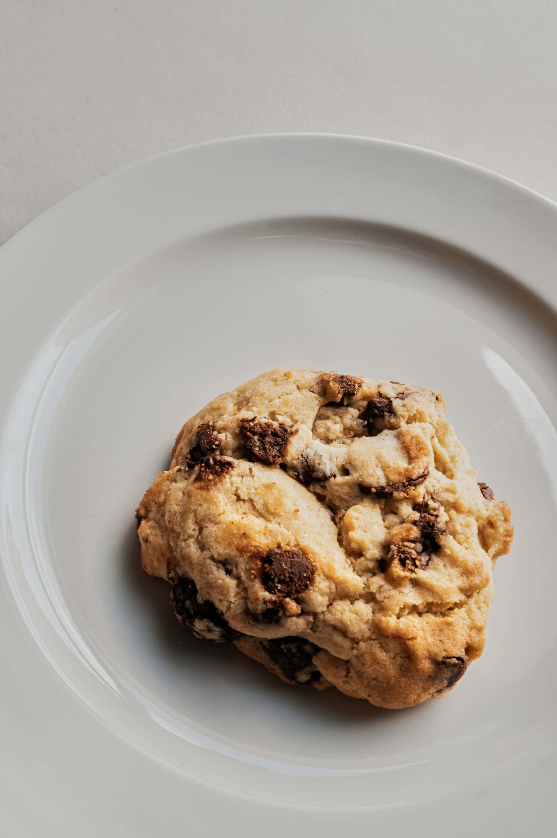 homemade chocolate chip cookie, white plate, neutral background, 2K Phone Wallpaper
