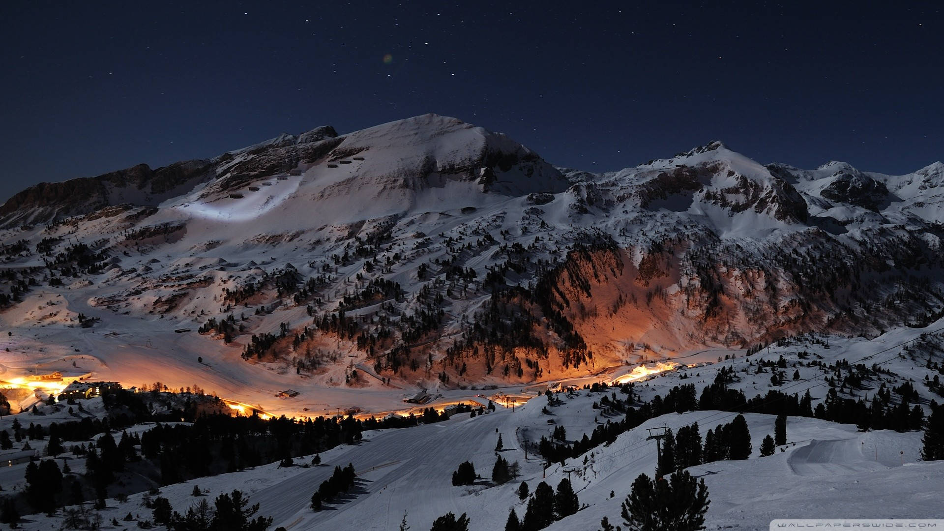 yellow-lit village, snowy mountain peaks, starry night sky, Full HD Desktop Wallpaper