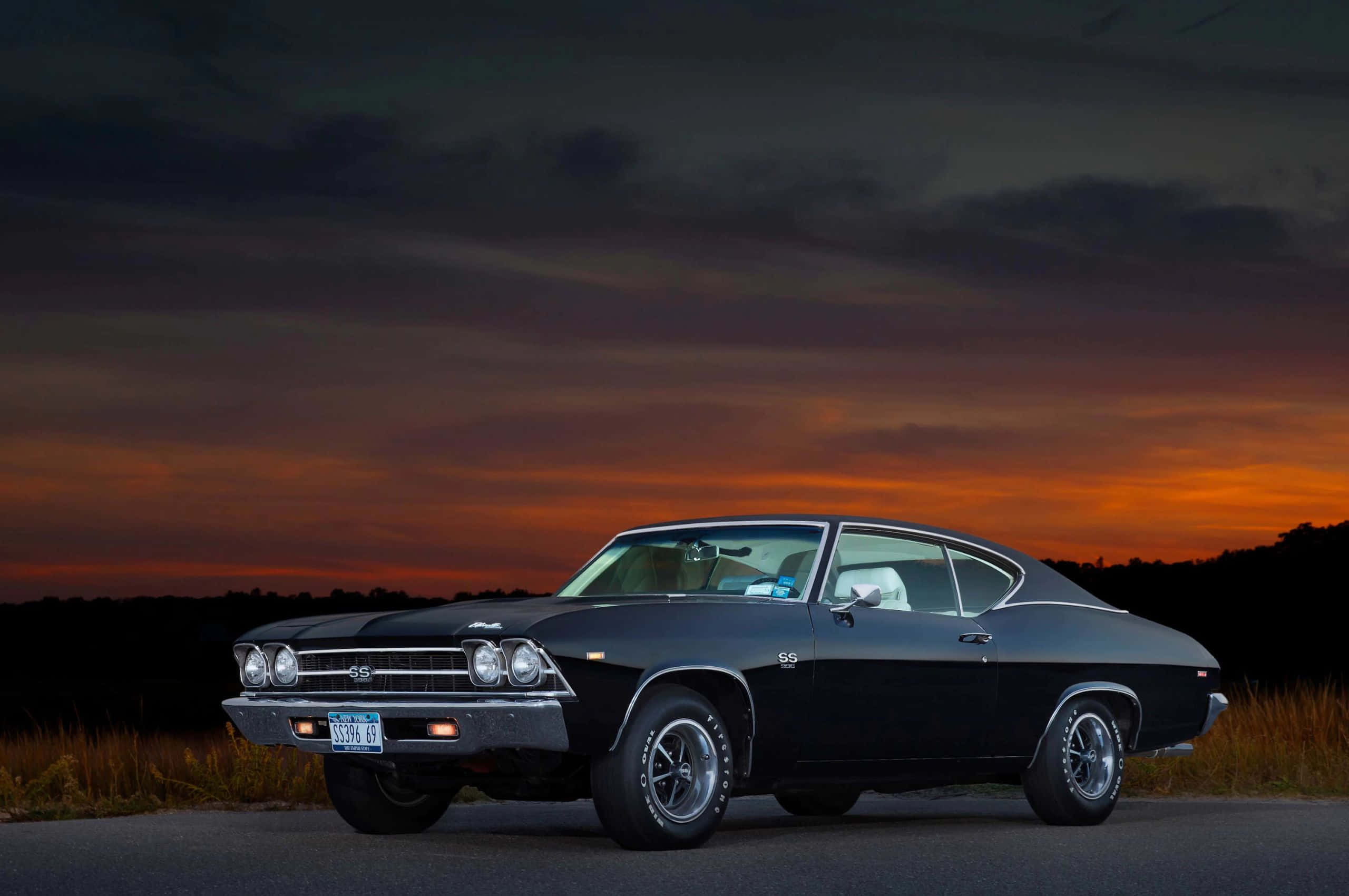 2560x1700, sleek black classic muscle car, fiery orange and purple sunset sky, 2K Desktop Wallpaper