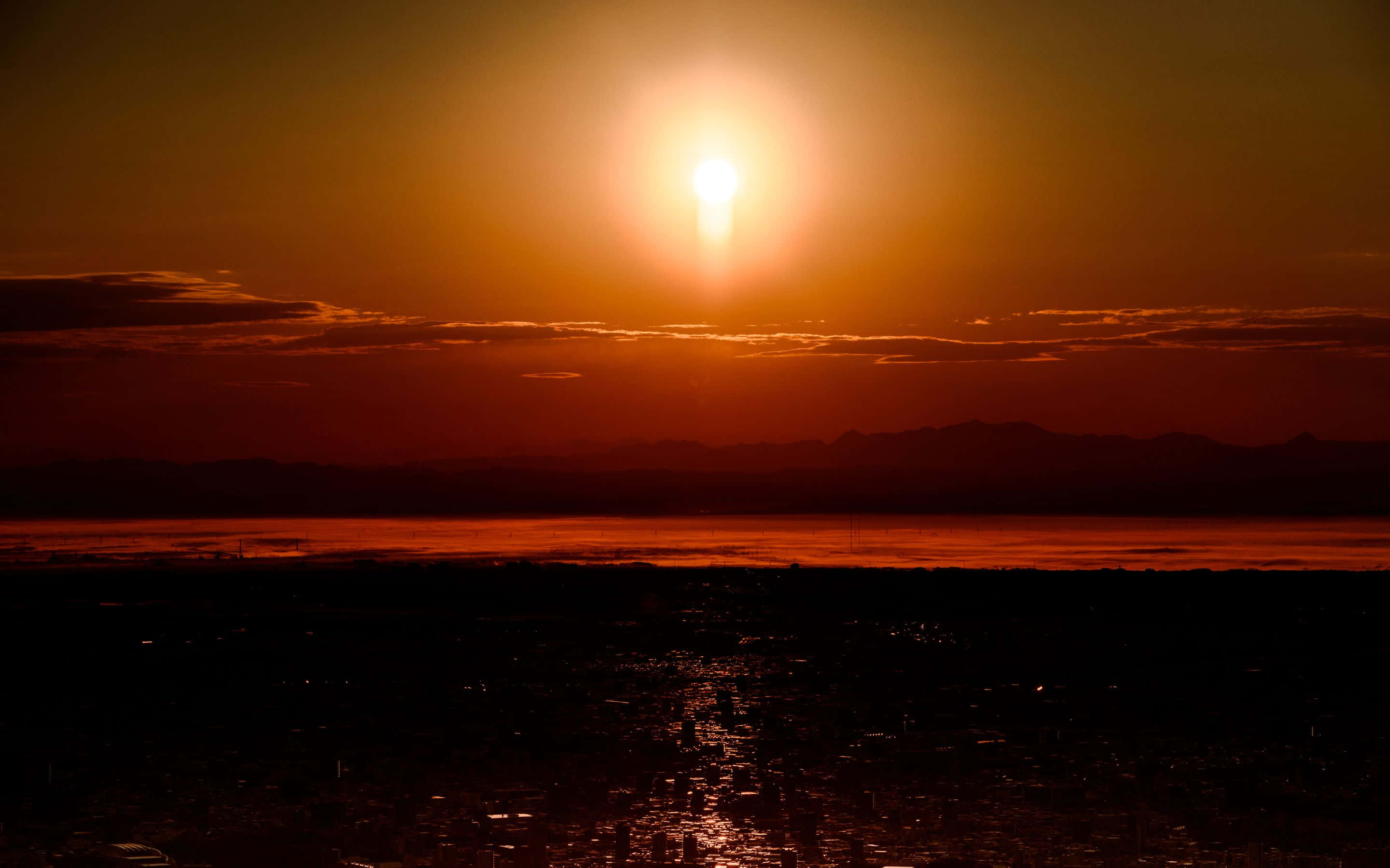 fiery sunset, distant mountain range, reflective water, 2K Desktop Wallpaper