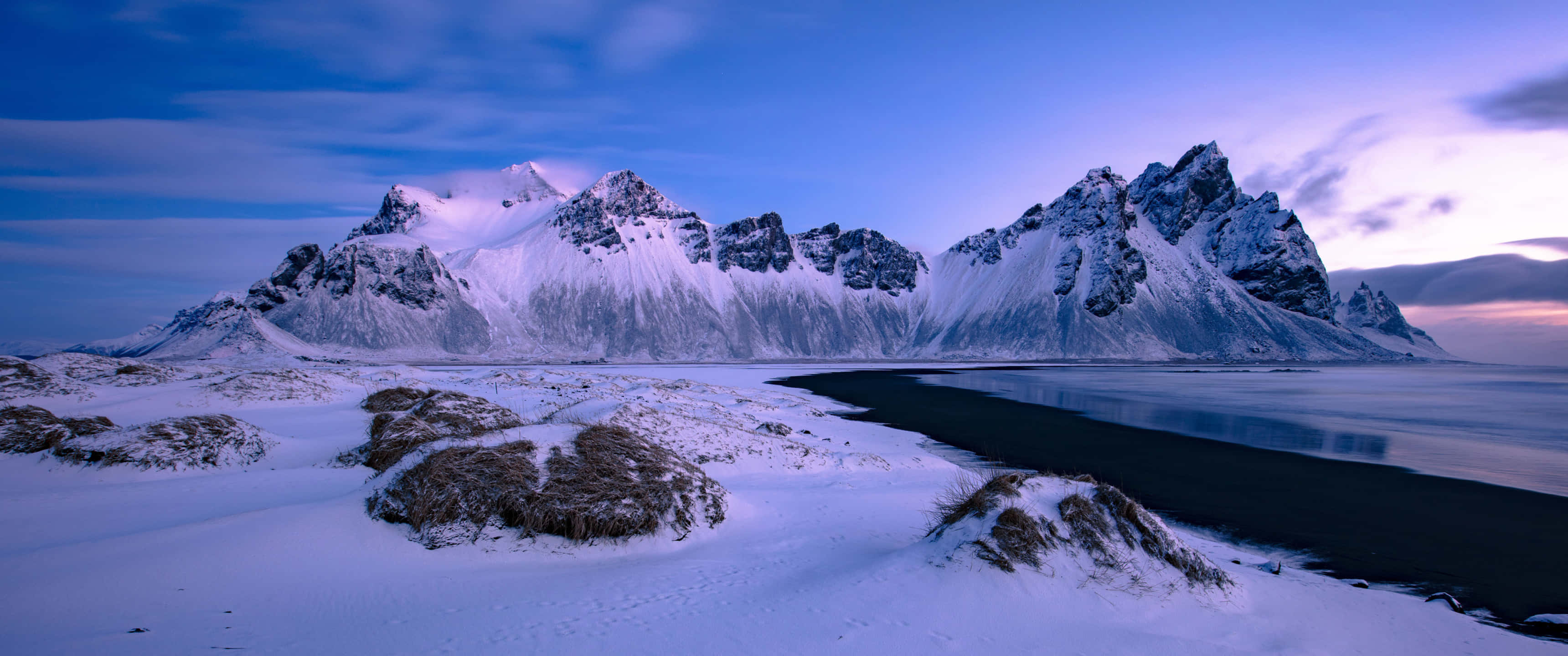 snow-covered evergreen trees, tranquil lake, snowcapped jagged mountains, 2K Desktop Wallpaper
