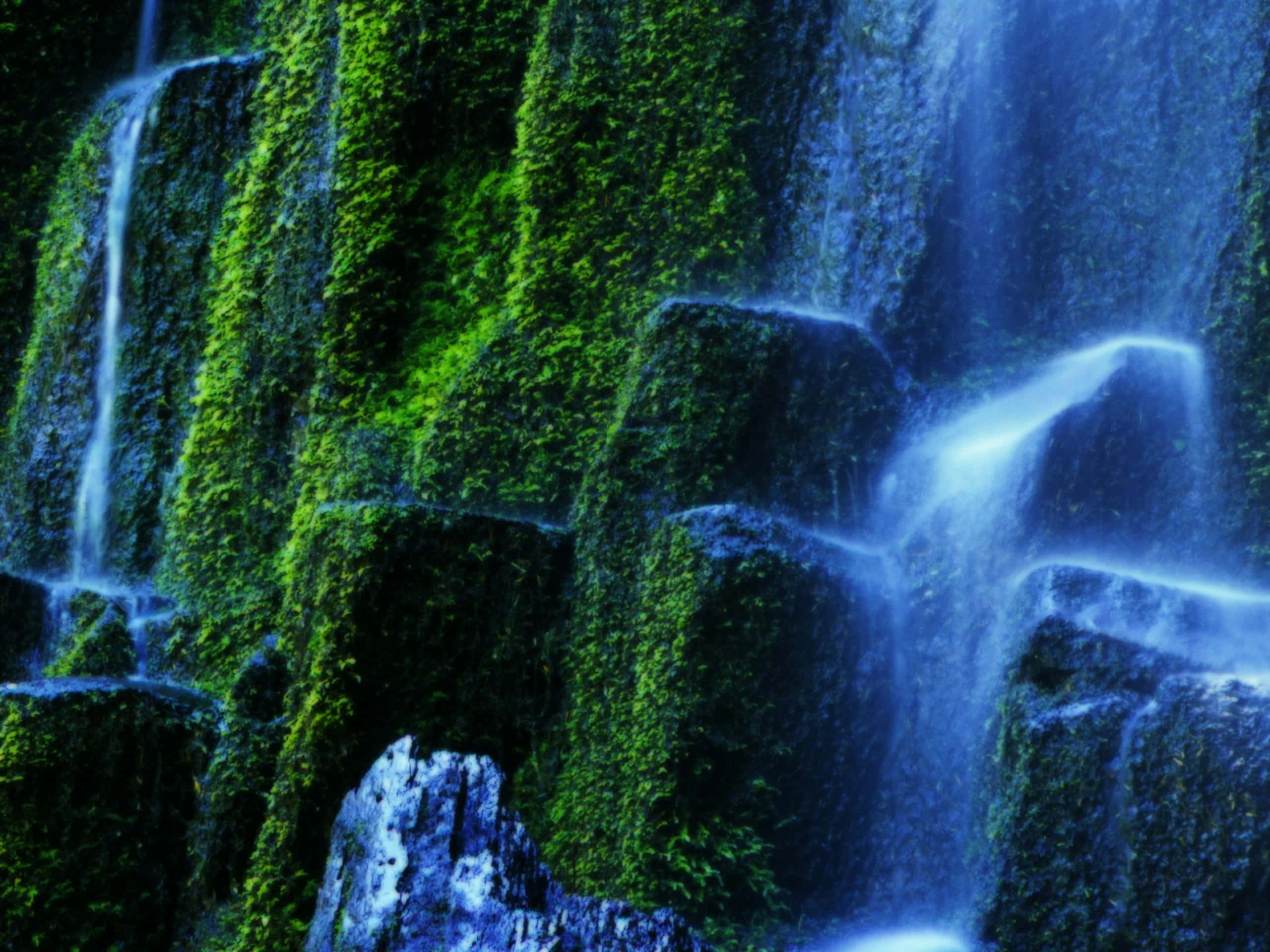 3d waterfall, mossy rocks, vibrant green light, 2K Desktop Wallpaper
