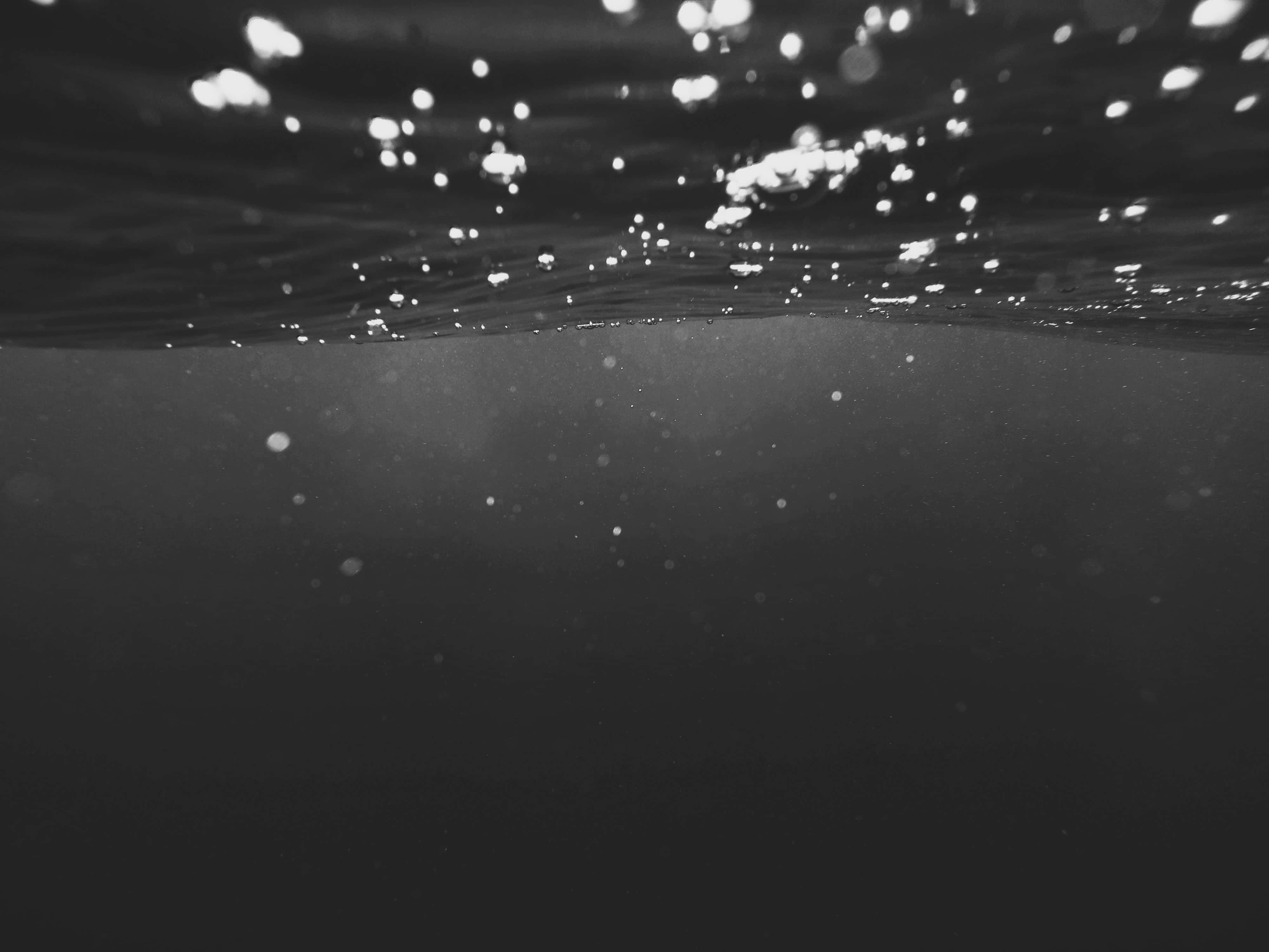 underwater black ocean, sparkling lights, rippling surface, 4K Desktop Wallpaper