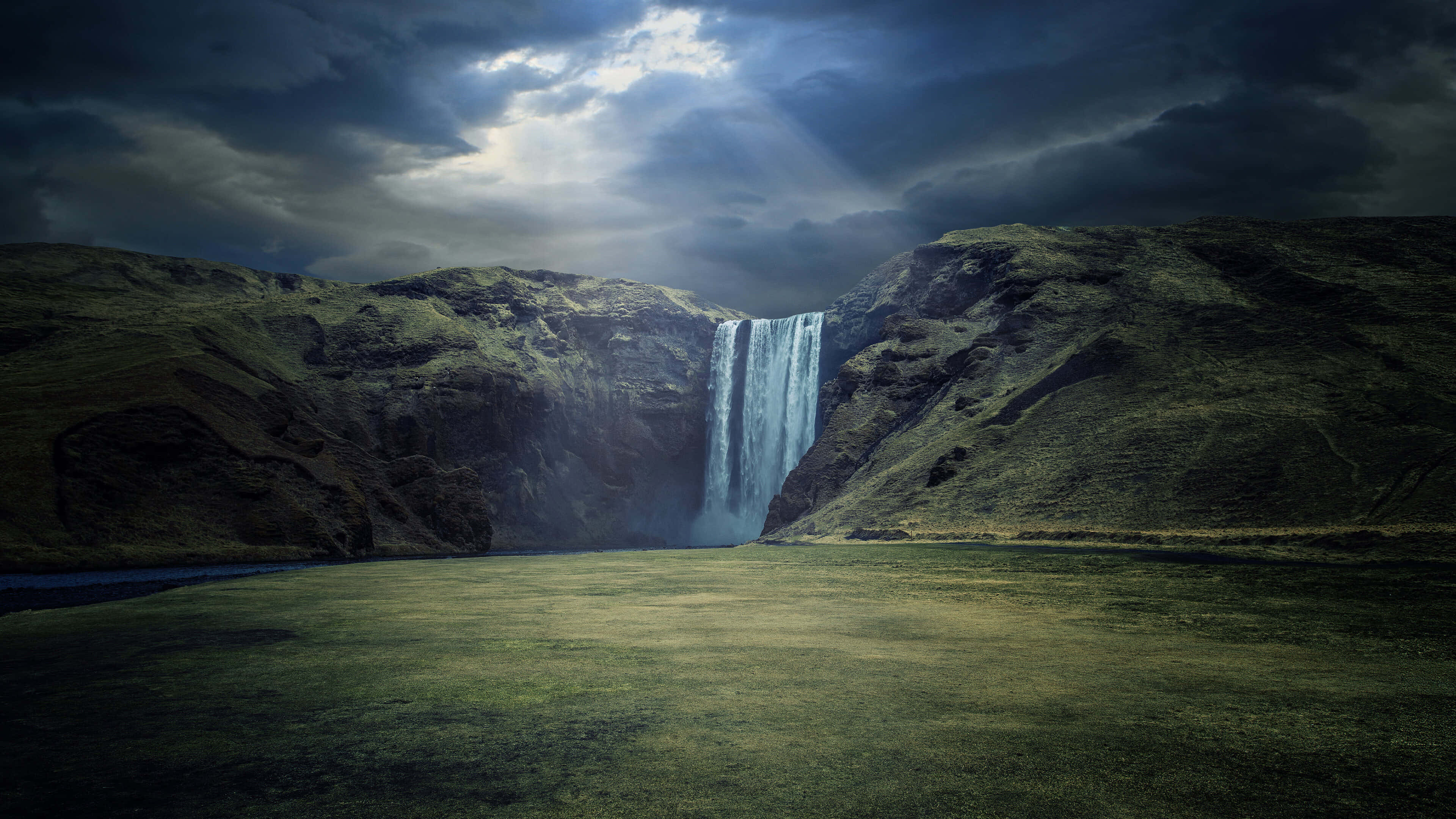 majestic waterfall, rugged green hills, dramatic cloudy sky, 4K Desktop Wallpaper