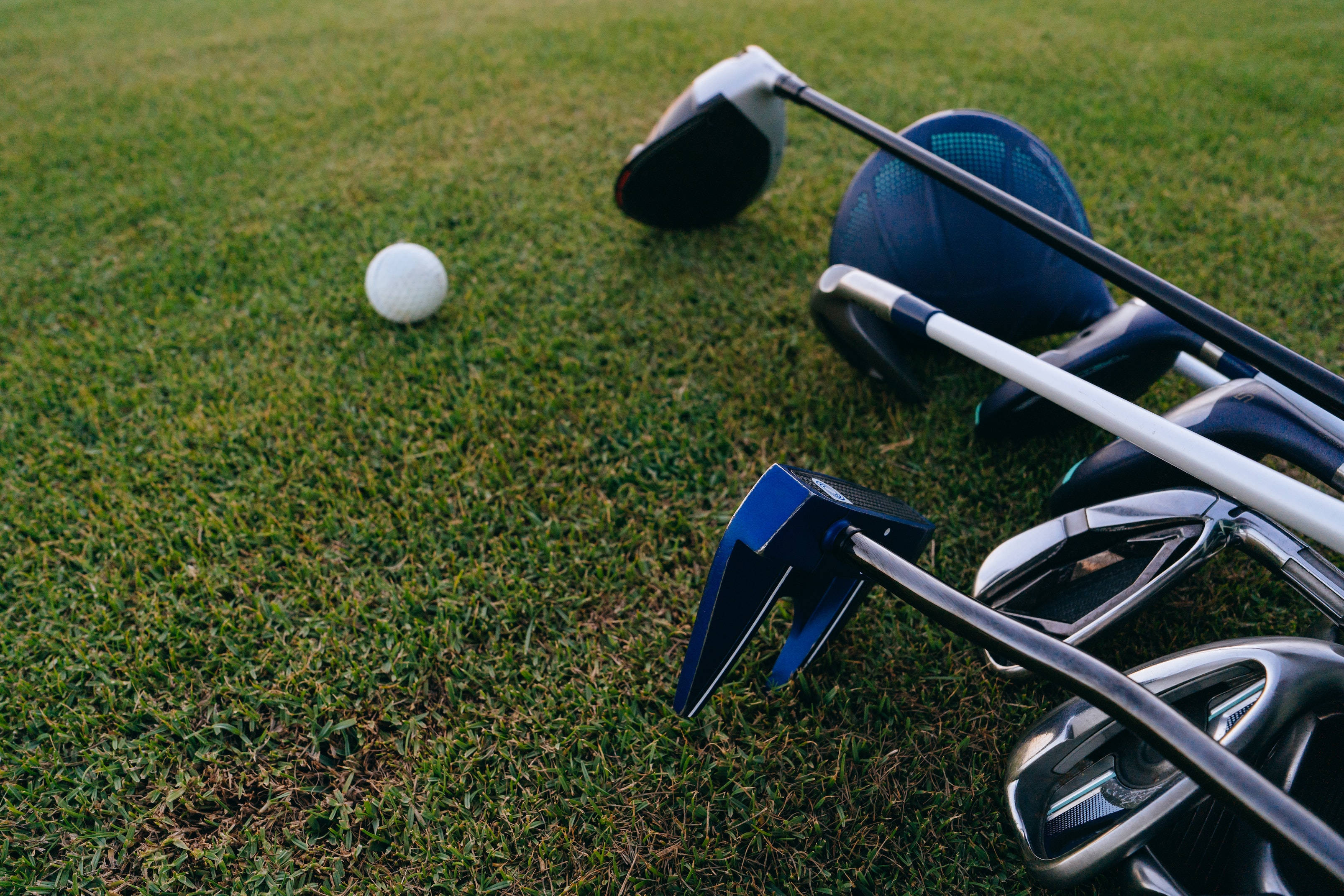 4K Golf Clubs And Ball, vibrant green grass, soft daylight, 2K Desktop Wallpaper