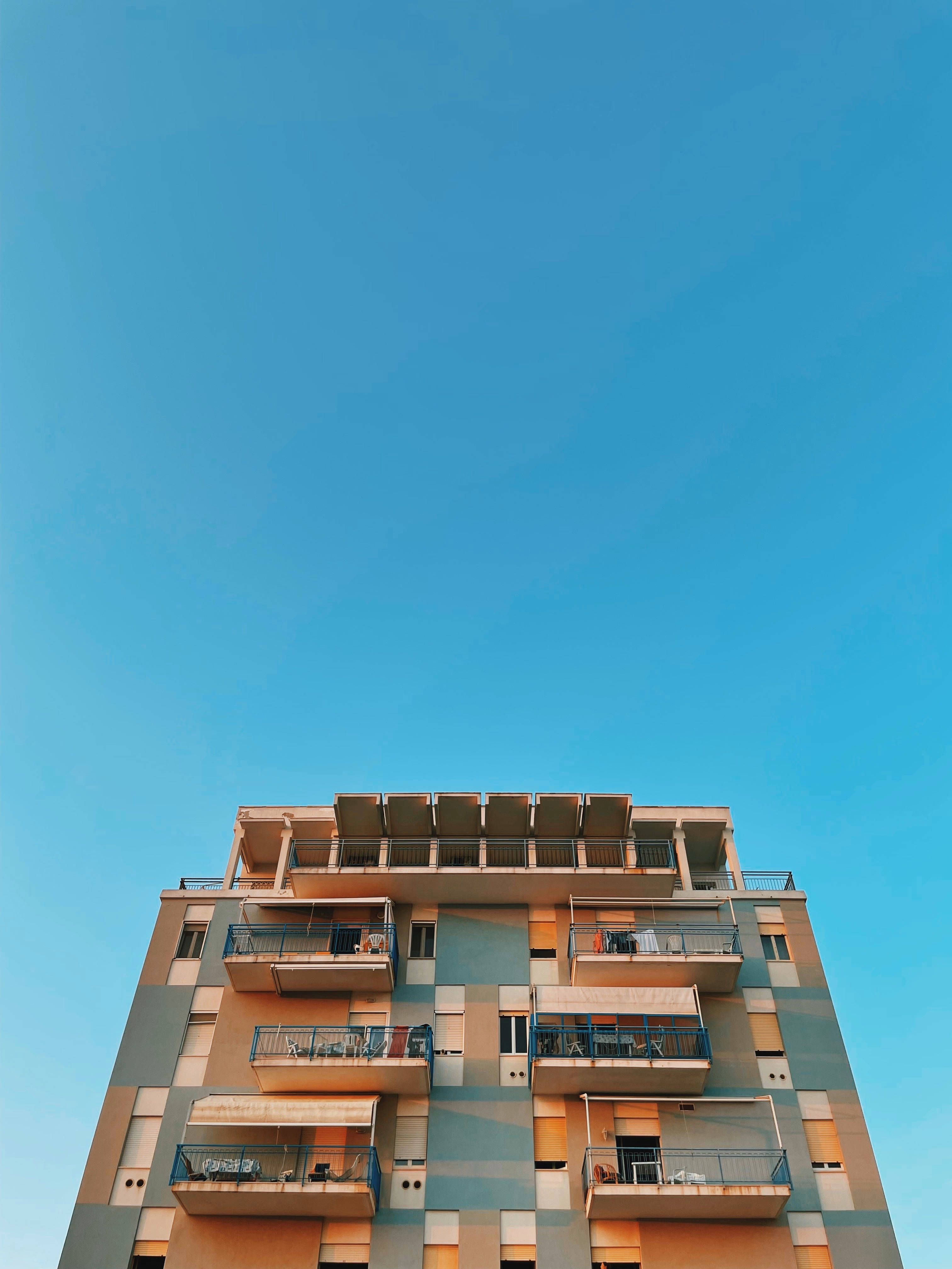 colorful balconies, modern apartment building, clear blue sky, 4K Phone Wallpaper