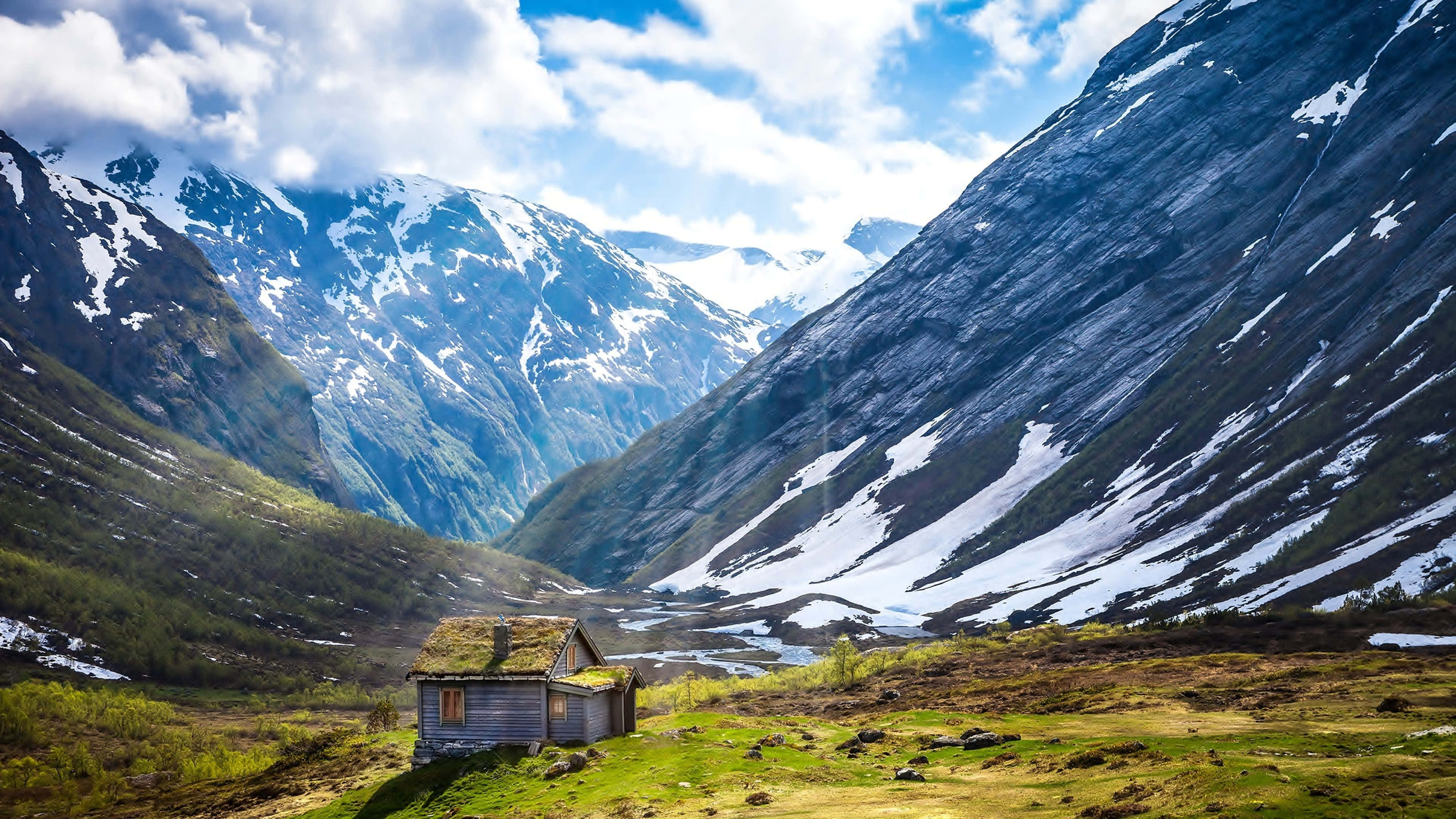 moss-roofed cabin, sunlit valley, snow-dusted mountains, 4K Desktop Wallpaper