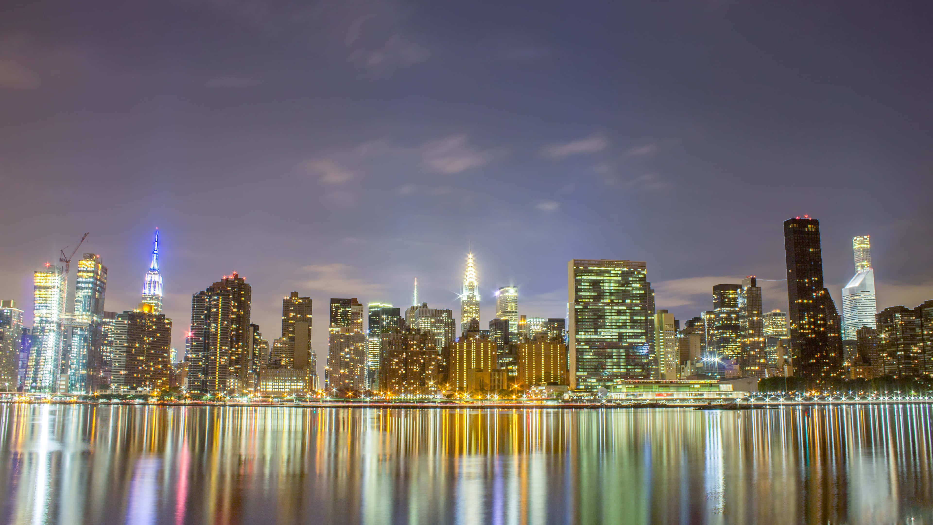 New York skyline, illuminated skyscrapers, calm water, 4K Desktop Wallpaper