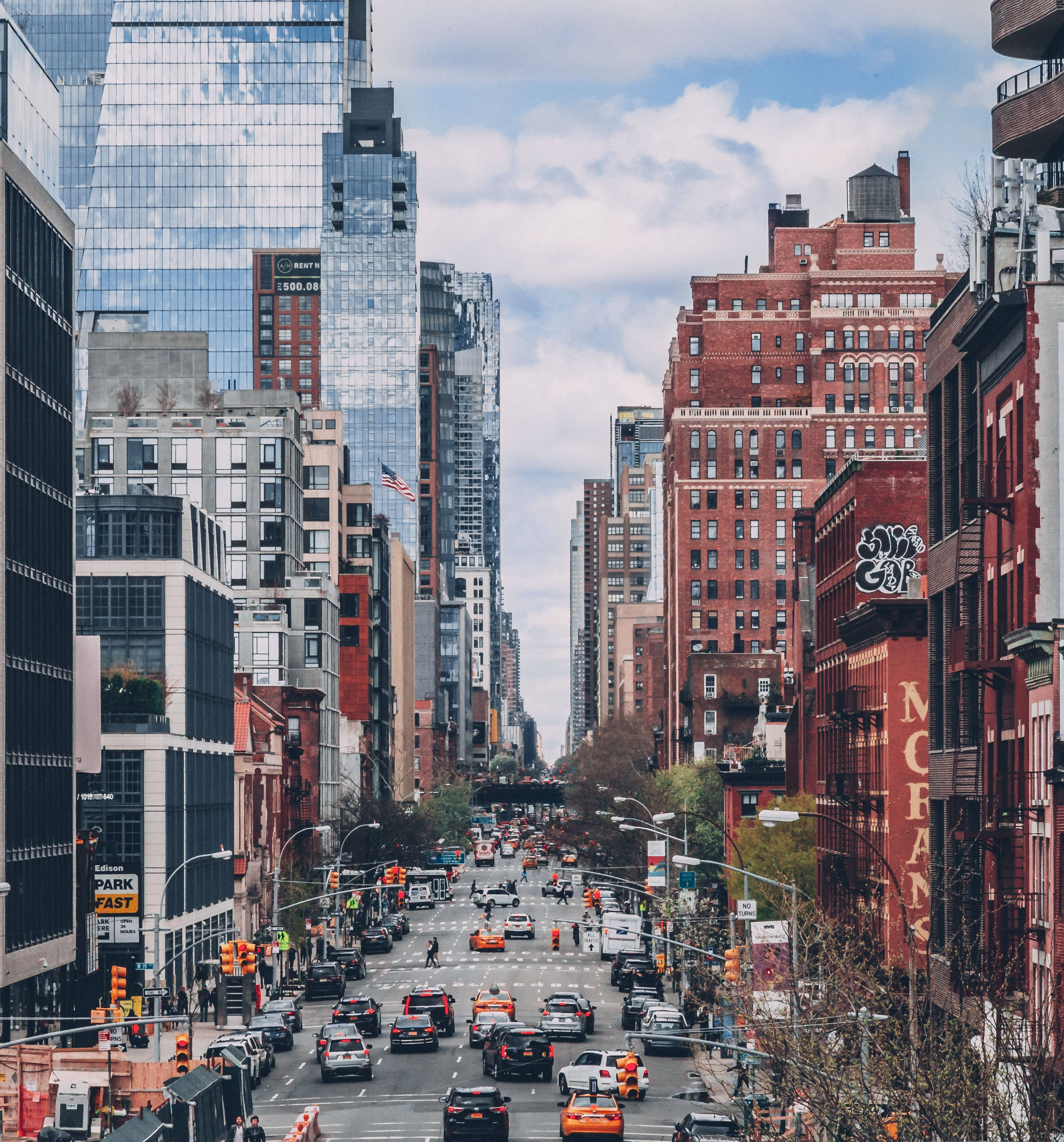 New York City, glass and brick buildings, partly cloudy sky, 2K Phone Wallpaper