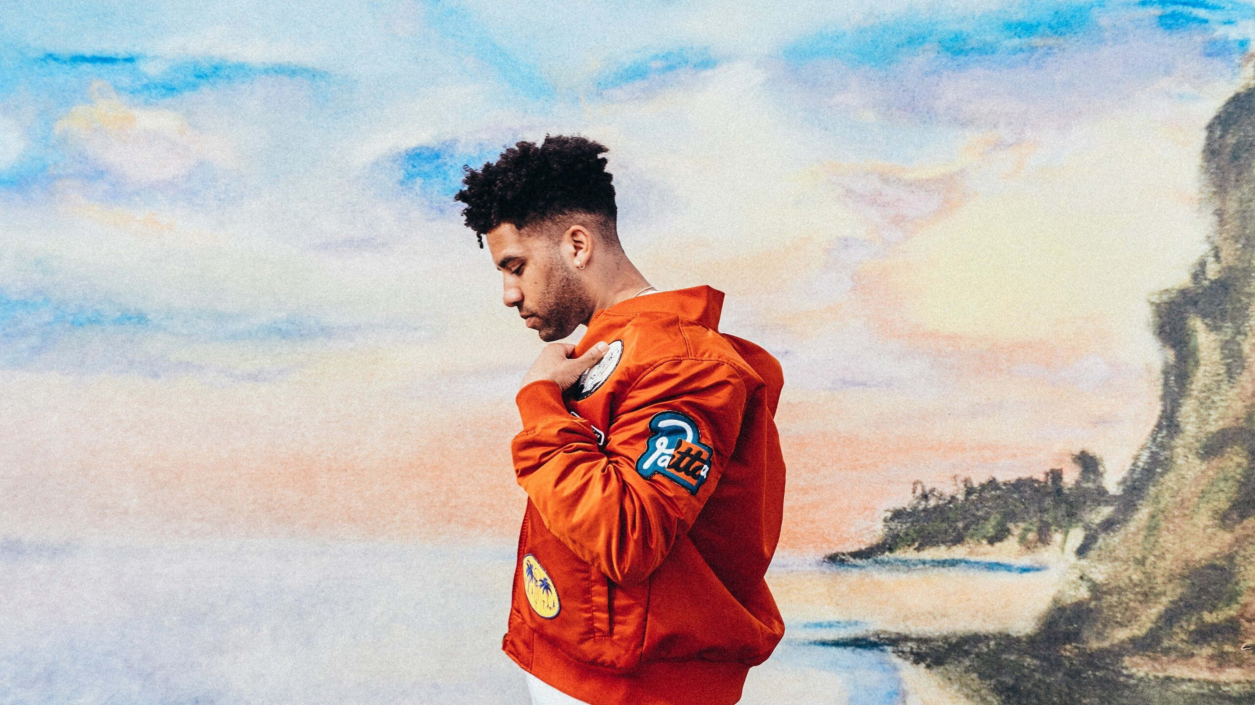 4K Rapper, bright orange jacket, watercolor-style coastal backdrop, 4K Desktop Wallpaper