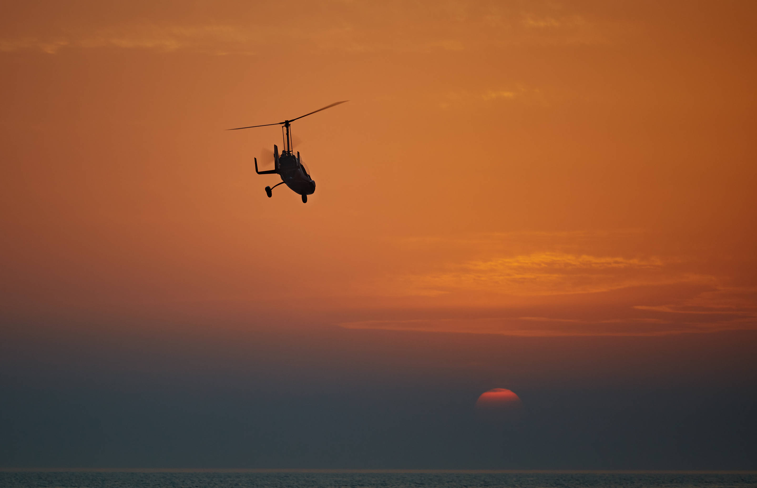 helicopter, fiery orange sunset, calm ocean waters, 2K Desktop Wallpaper
