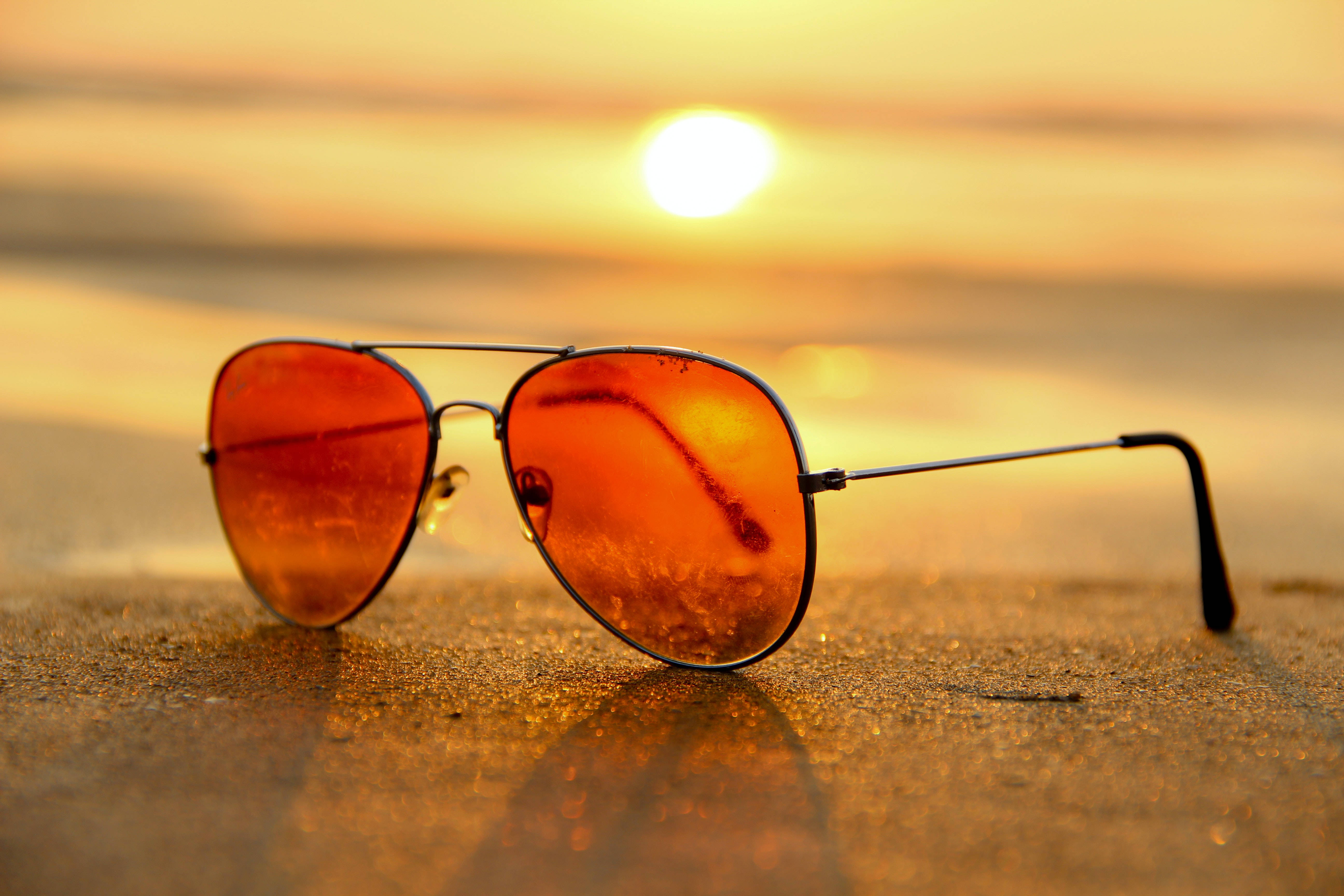 Aviator sunglasses, sandy beach, golden sunset hues, 5K Desktop Wallpaper