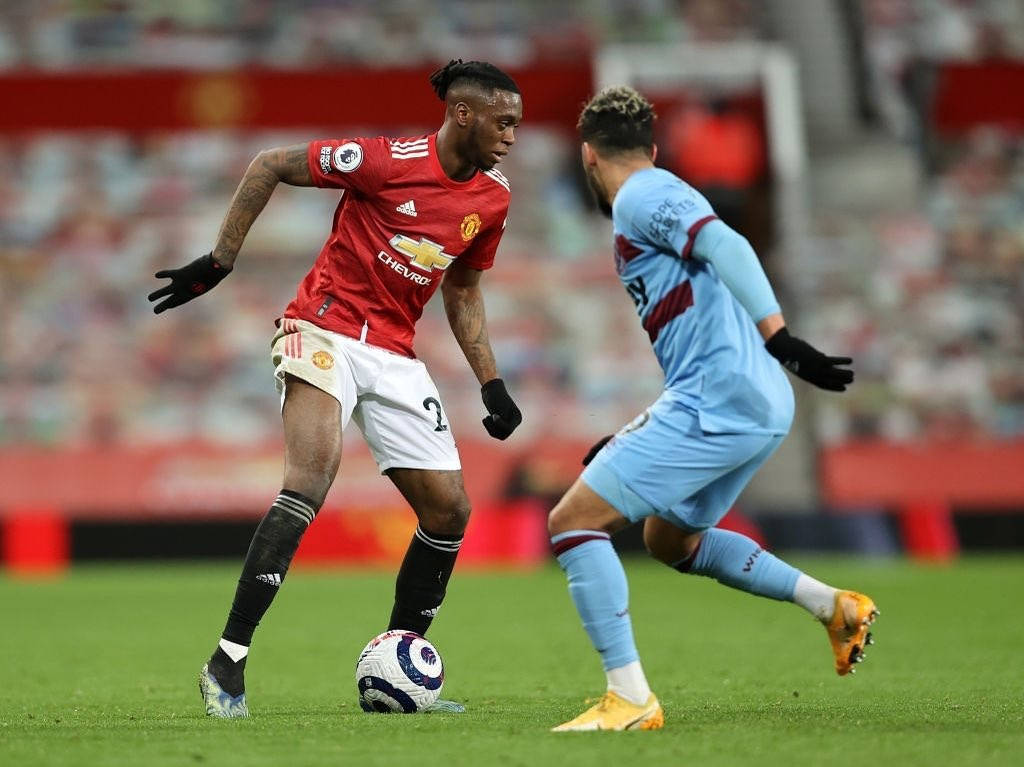 Aaron Wan-Bissaka, vibrant green pitch, stadium lights, SD Desktop Wallpaper