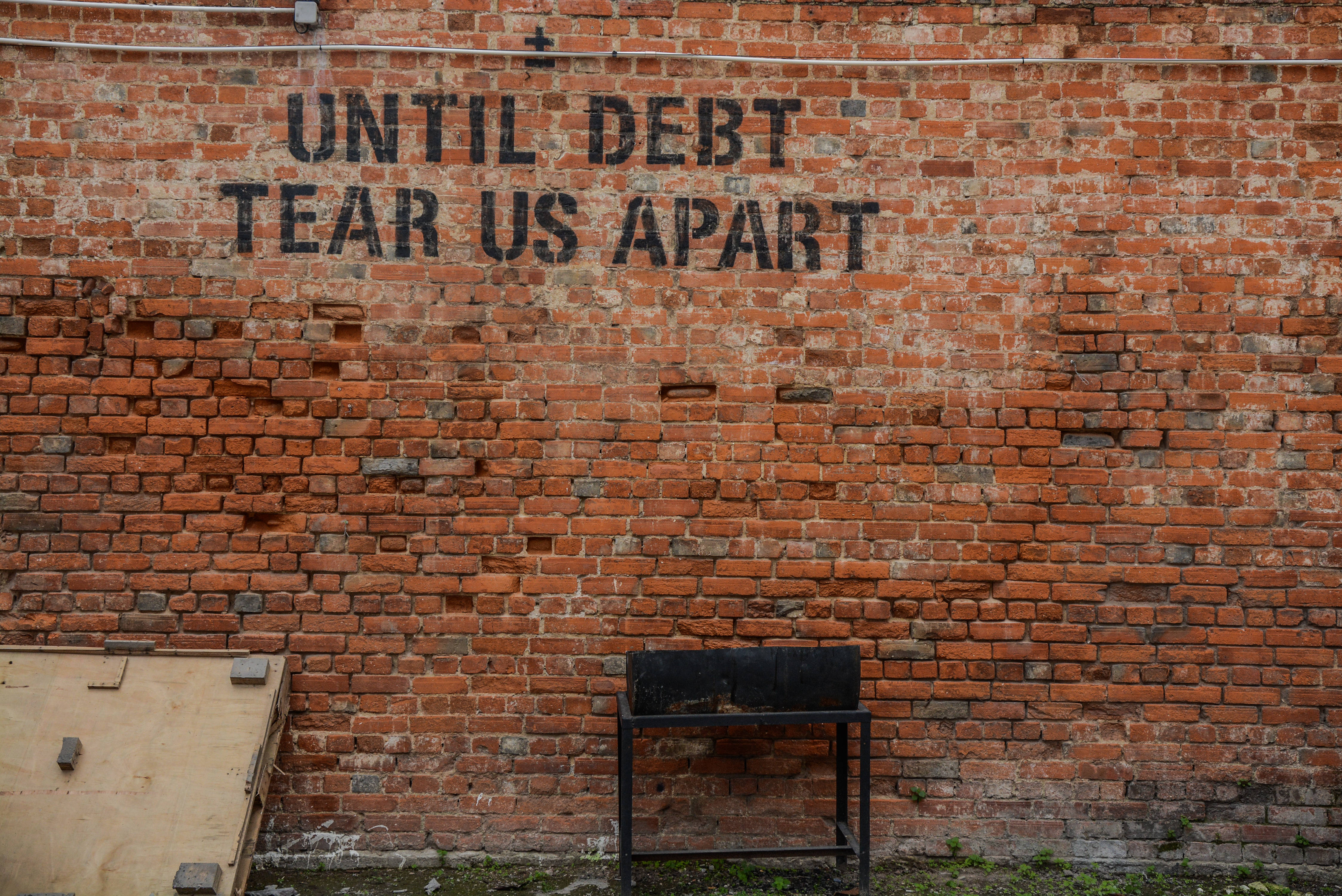 UNTIL DEBT TEAR US APART, weathered brick wall, bold black graffiti, 4K Desktop Wallpaper