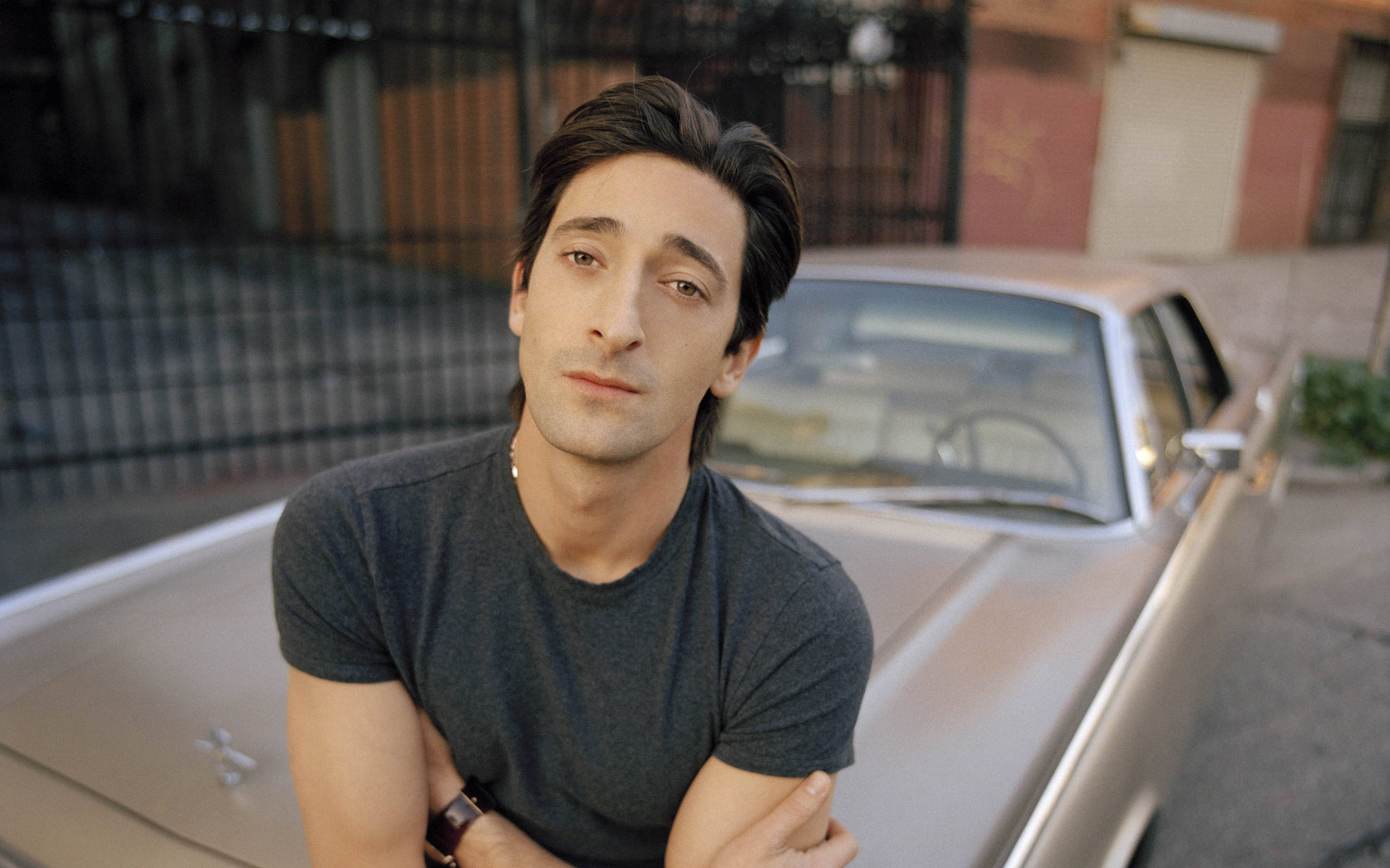 Adrien Brody, vintage silver car, urban alleyway, 2K Desktop Wallpaper