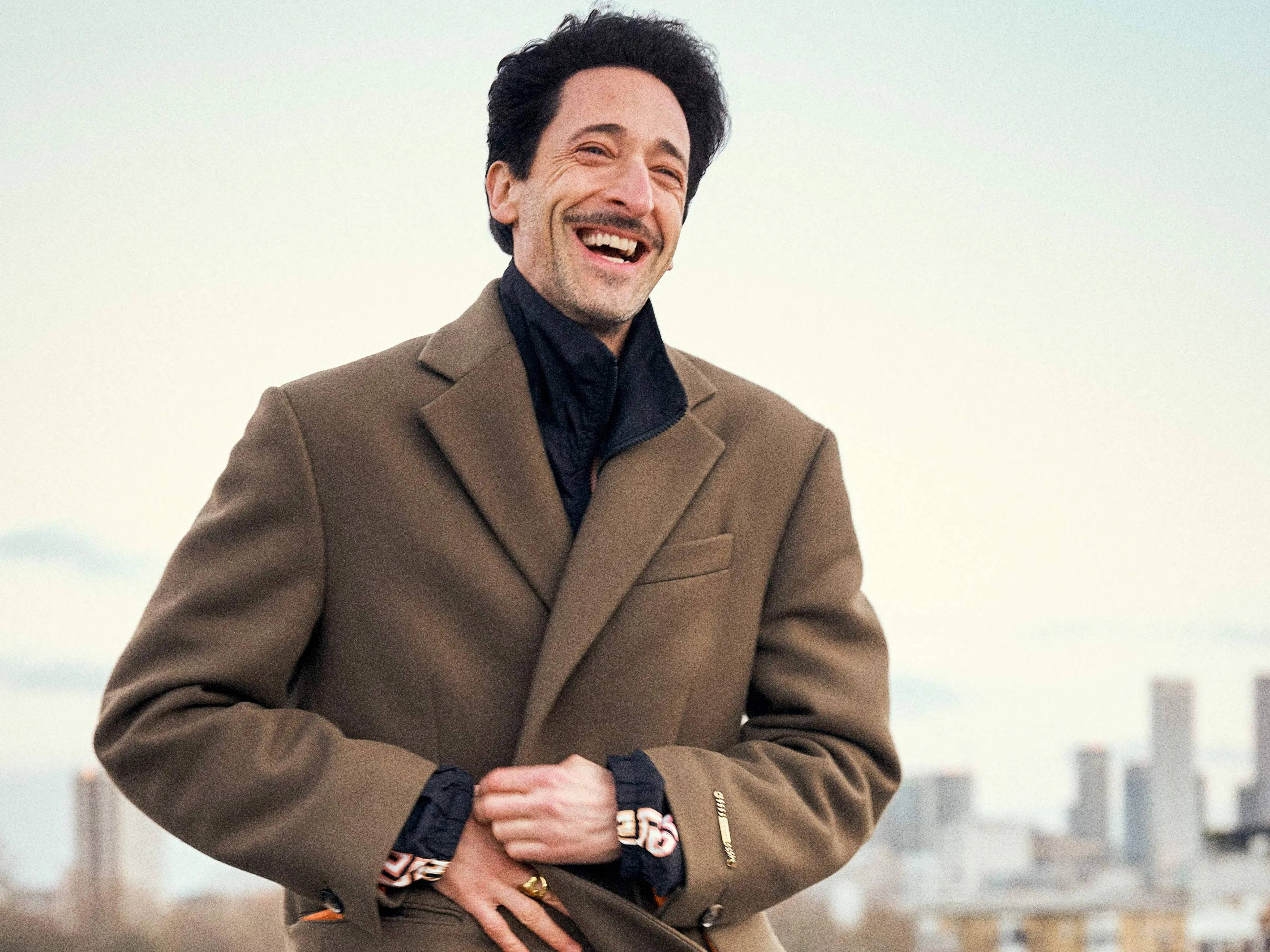 Adrien Brody, brown coat, city skyline, 2K Desktop Wallpaper