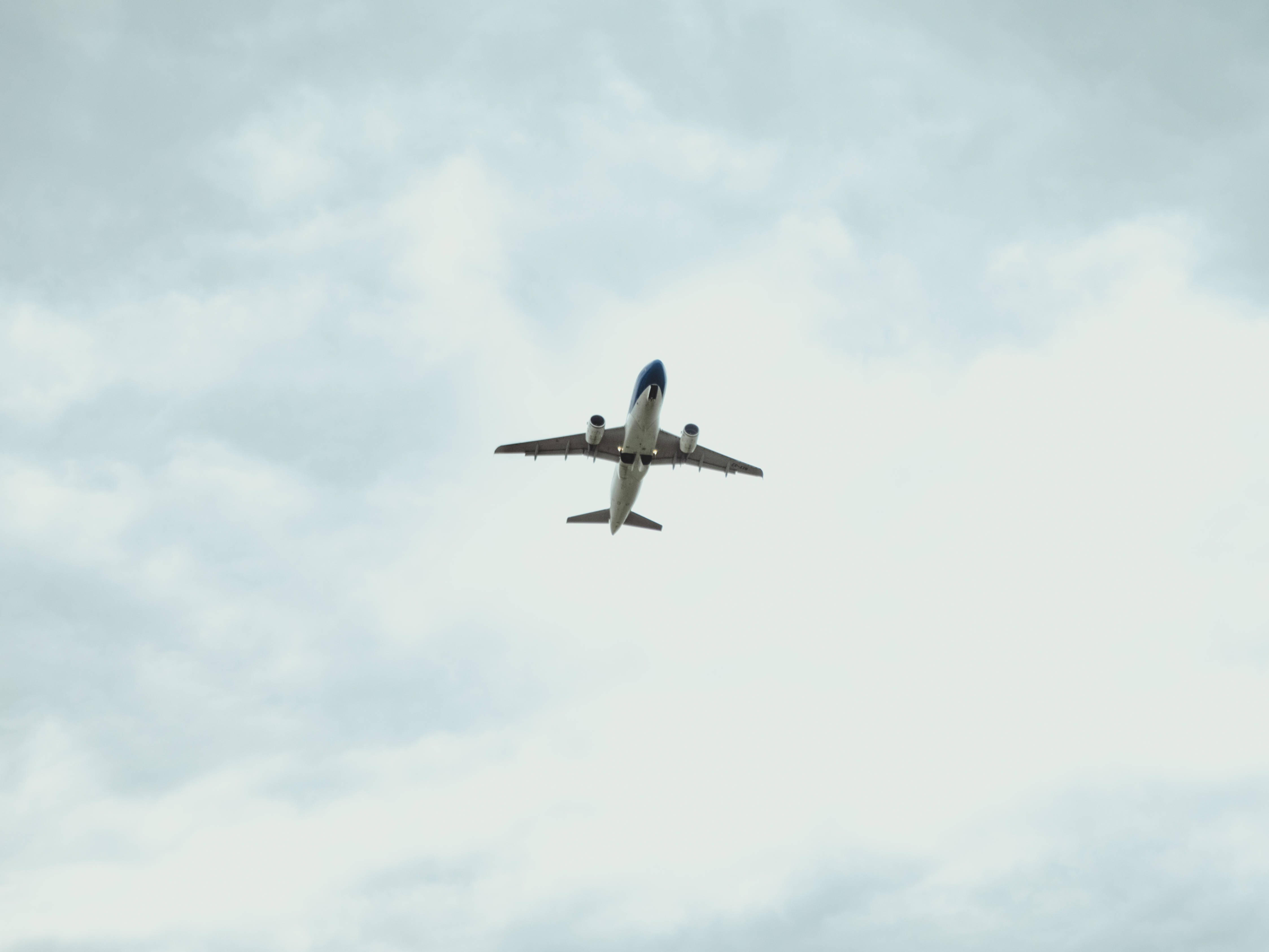 commercial airplane, soft gray cloudy sky, viewed from below, 4K Desktop Wallpaper