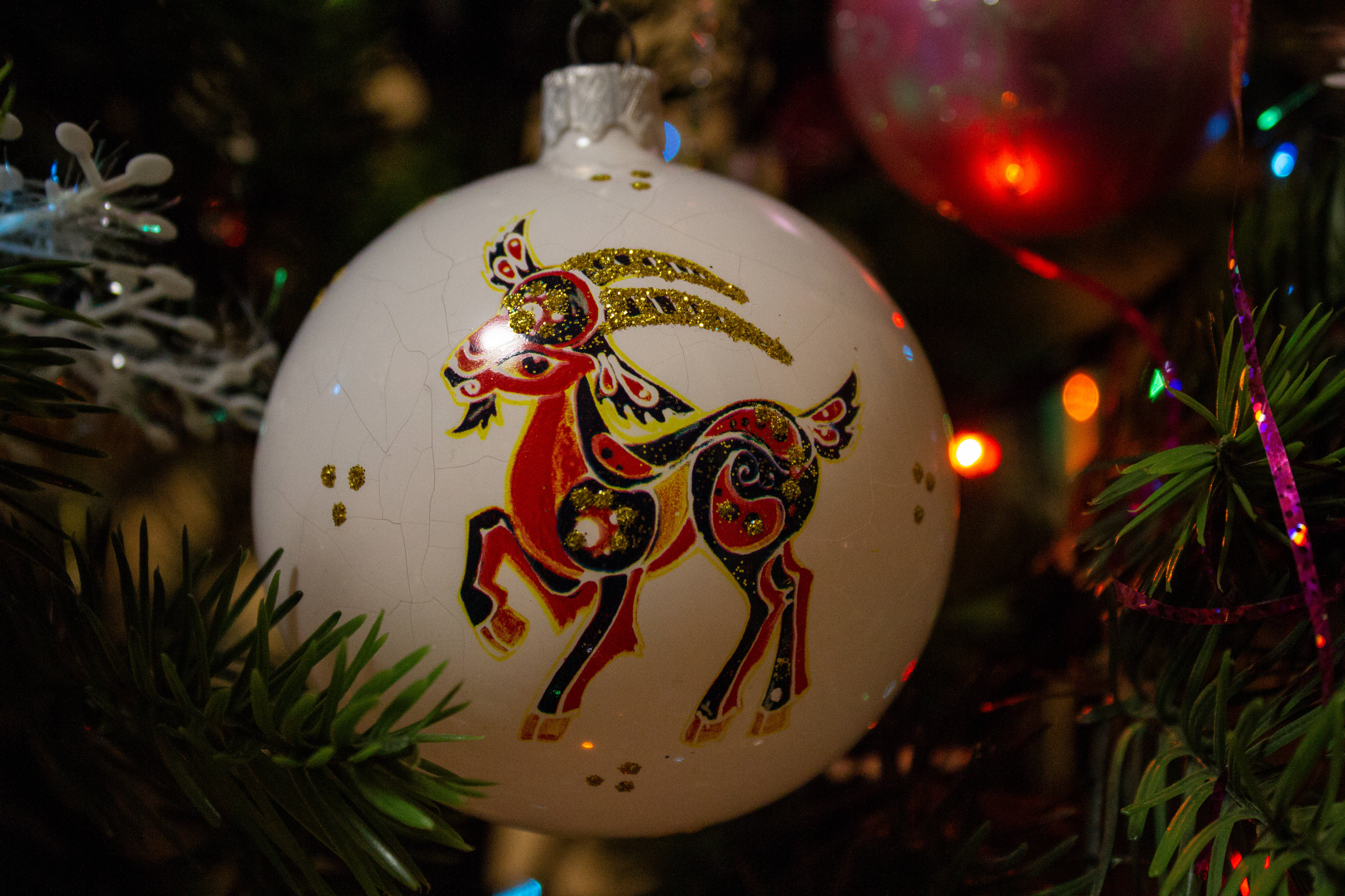 white Christmas ornament, vibrant red gold and black stylized horse design, pine tree, 5K Desktop Wallpaper