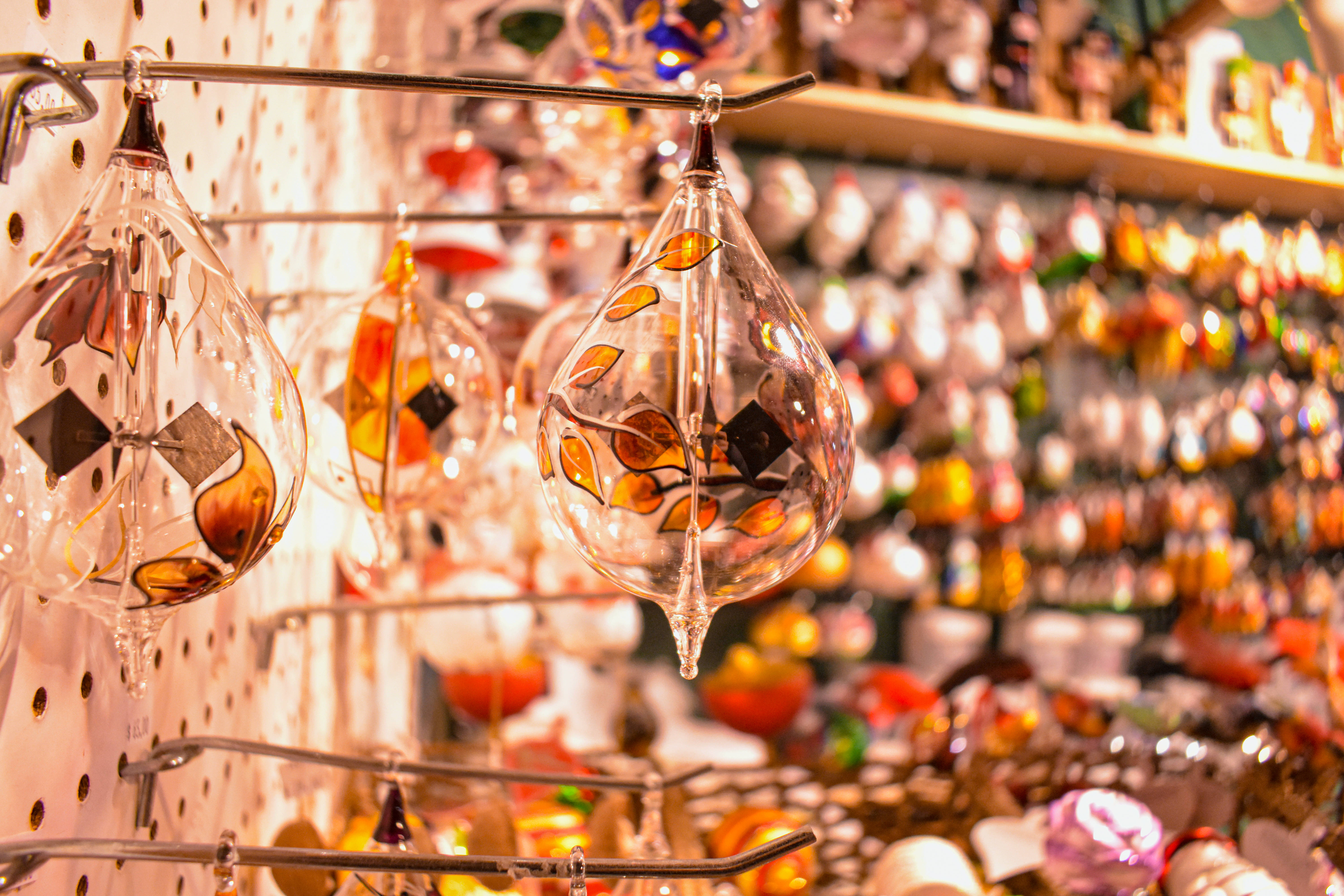 hand-blown glass ornaments, amber leaf patterns, bustling artisan shop, 5K Desktop Wallpaper