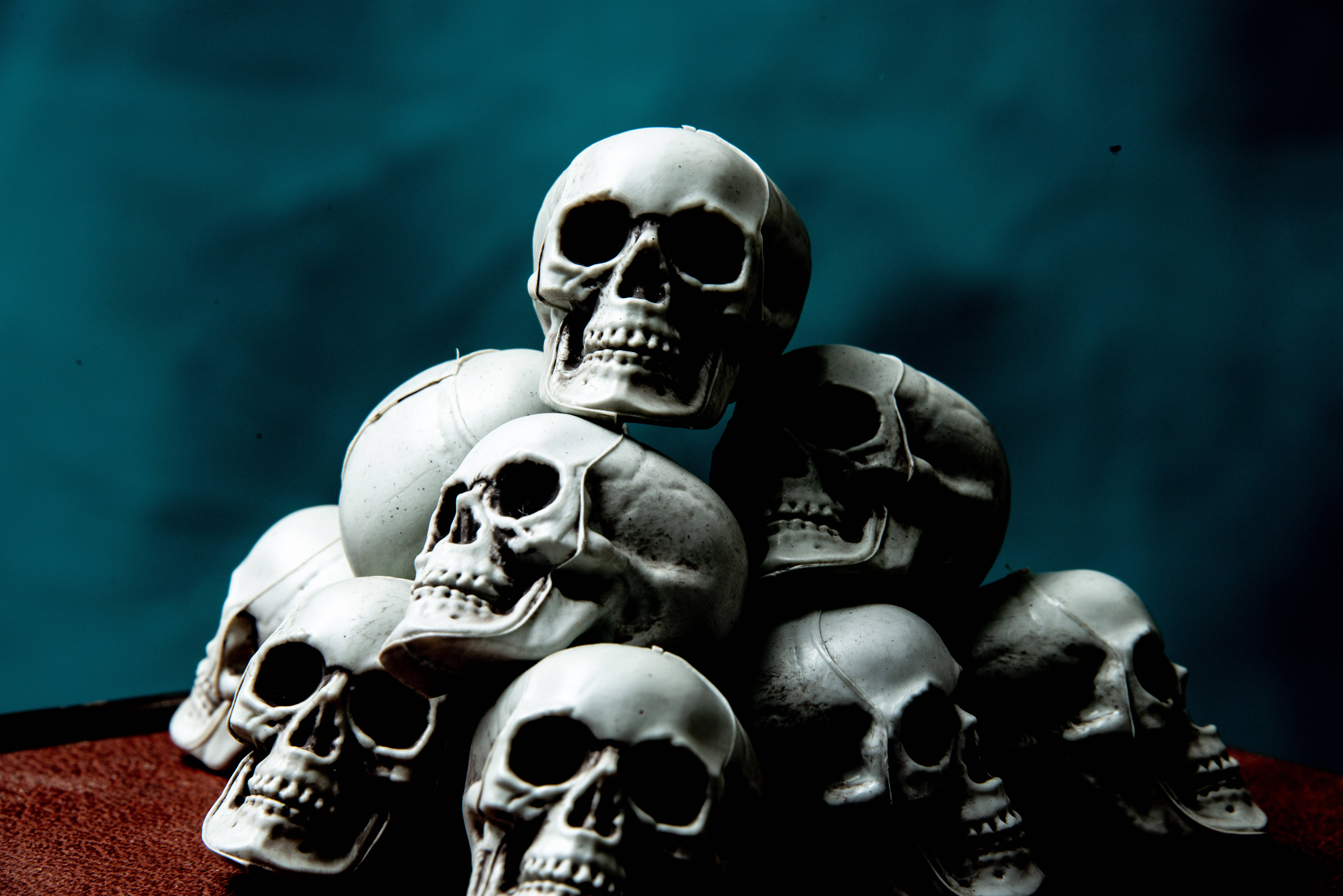 stacked skull, white plastic skulls, dark surface, 5K Desktop Wallpaper