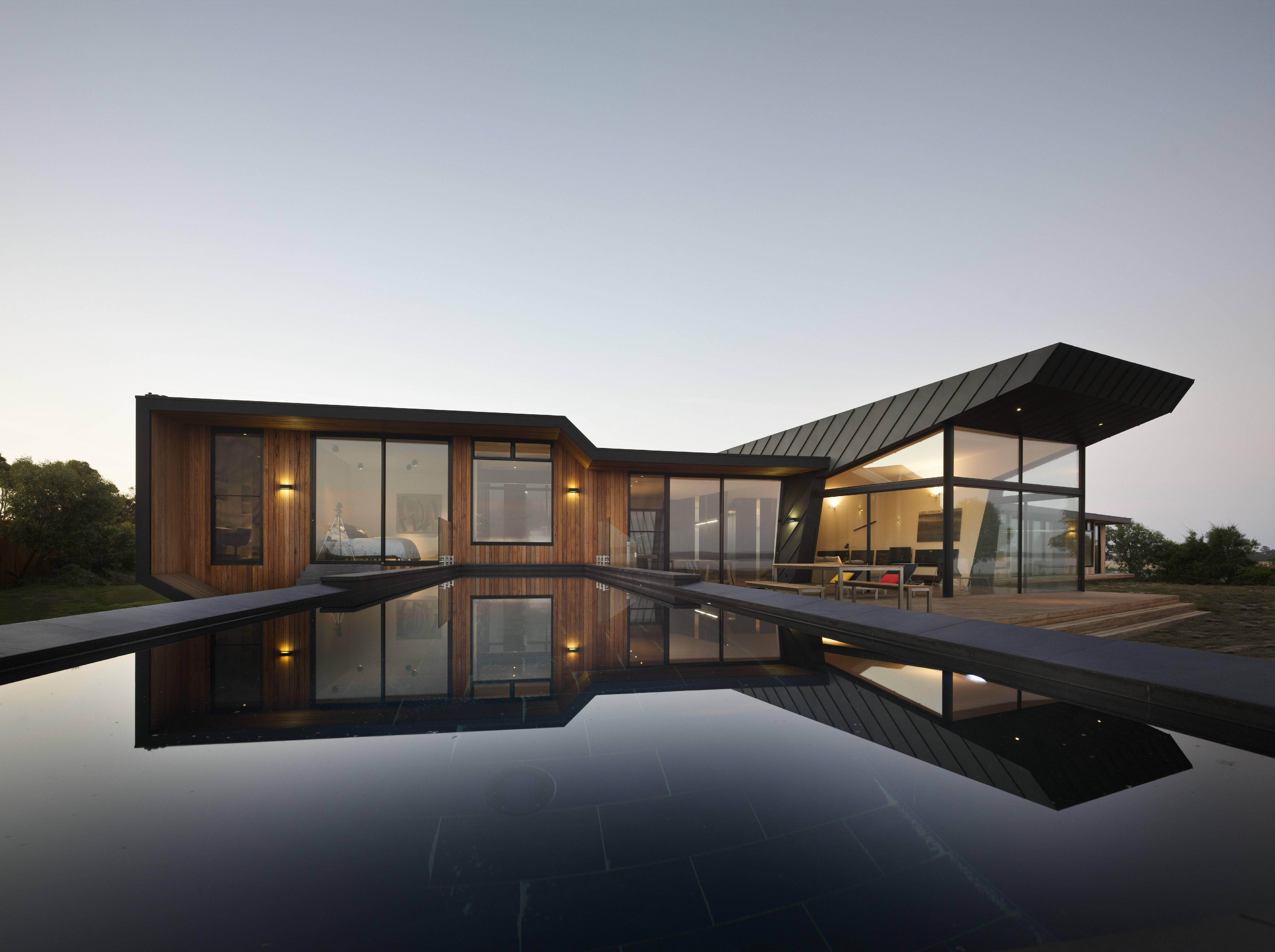 Modern glass and wood house, infinity pool, warm interior lights, 4K Desktop Wallpaper