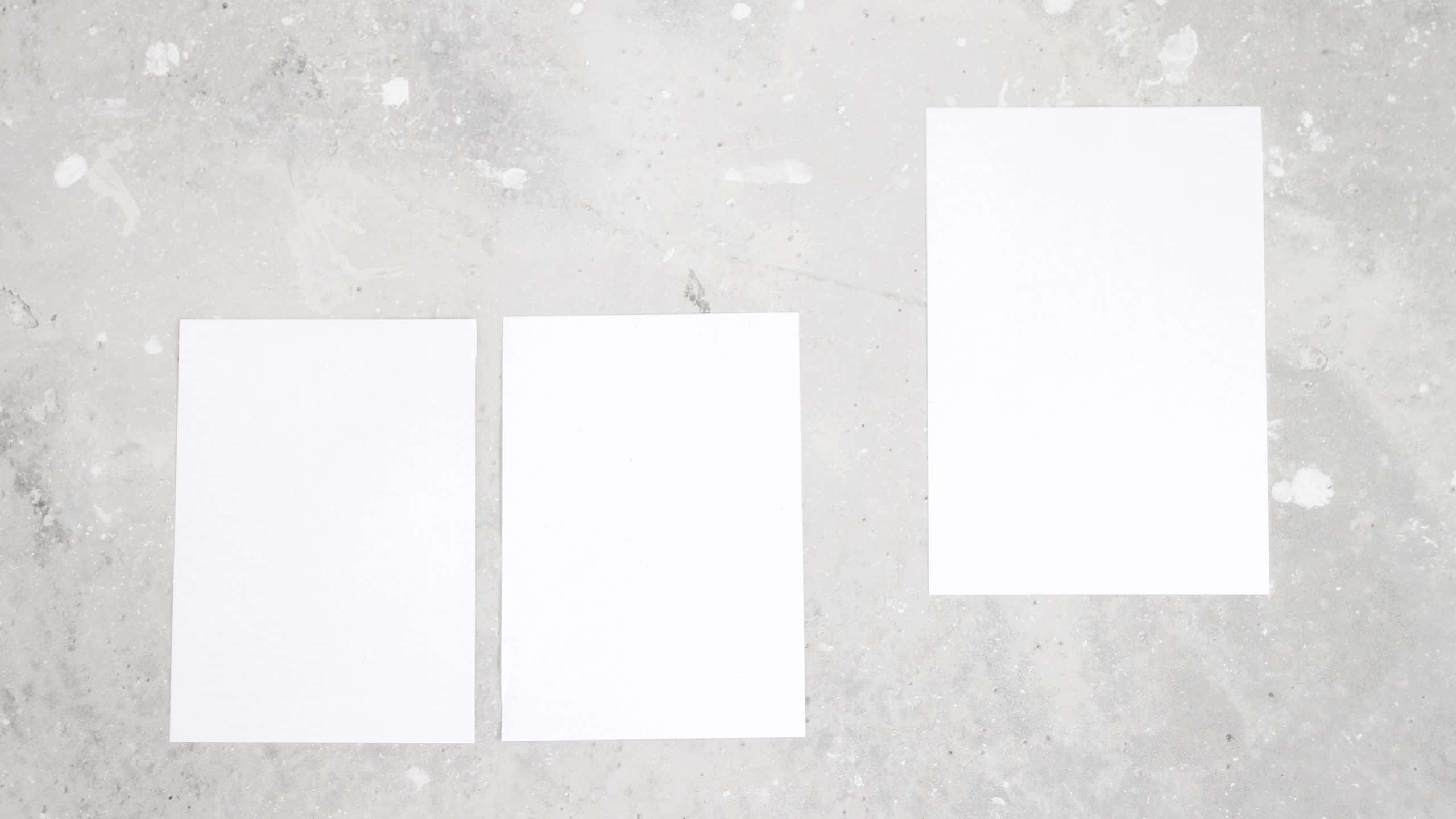 soft aesthetic computer, white paper sheets, textured gray concrete surface, 2K Desktop Wallpaper