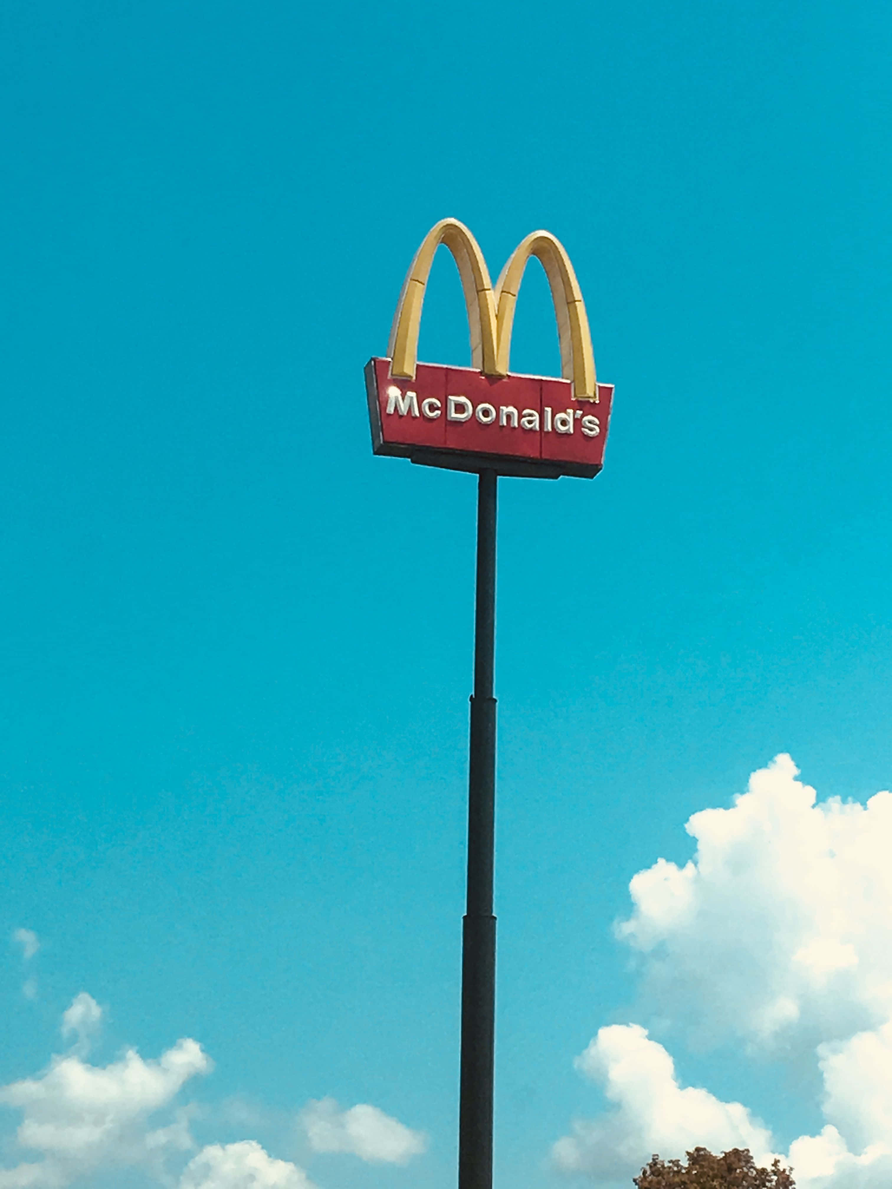 Aesthetic Mcdonalds, golden arches sign, vibrant blue sky, 4K Phone Wallpaper