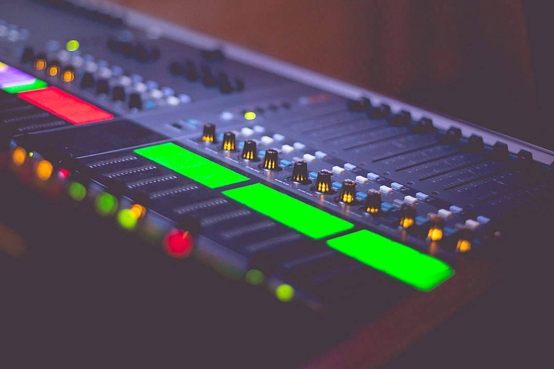 audio mixing console, glowing green red and amber lights, dark controls, SD Desktop Wallpaper