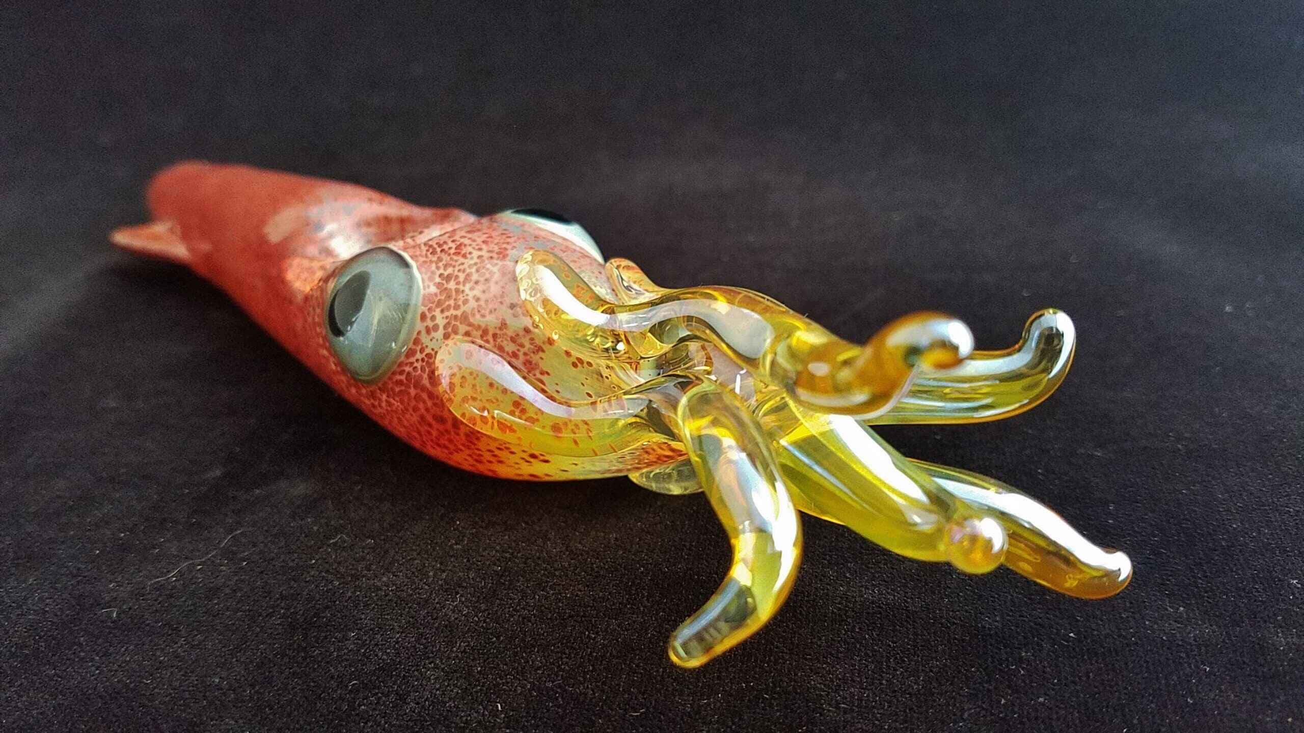 hand-blown glass squid sculpture, red speckled body, yellow tentacles, 2K Desktop Wallpaper