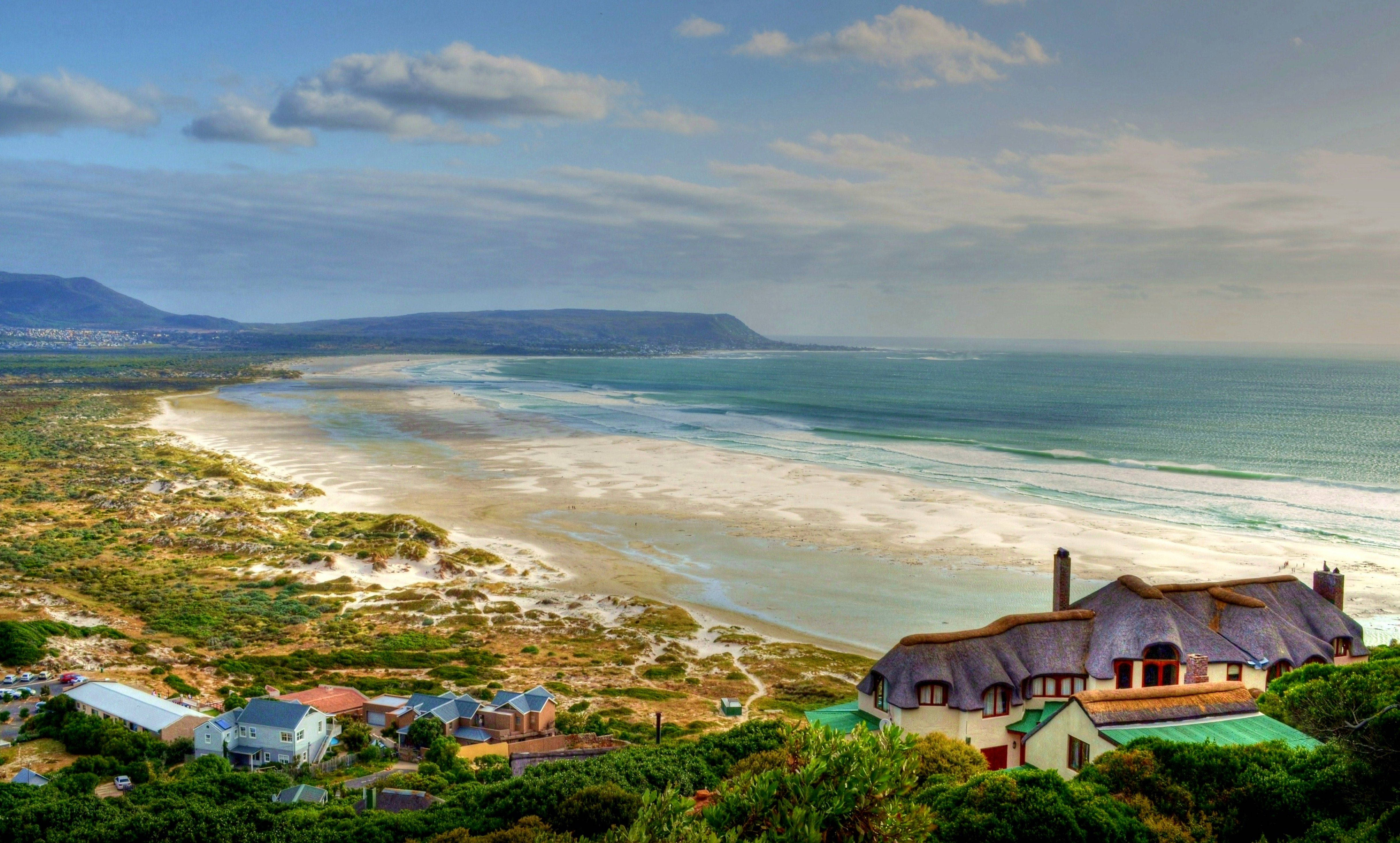 coastal village, thatched-roof houses, green cliffs, 4K Desktop Wallpaper