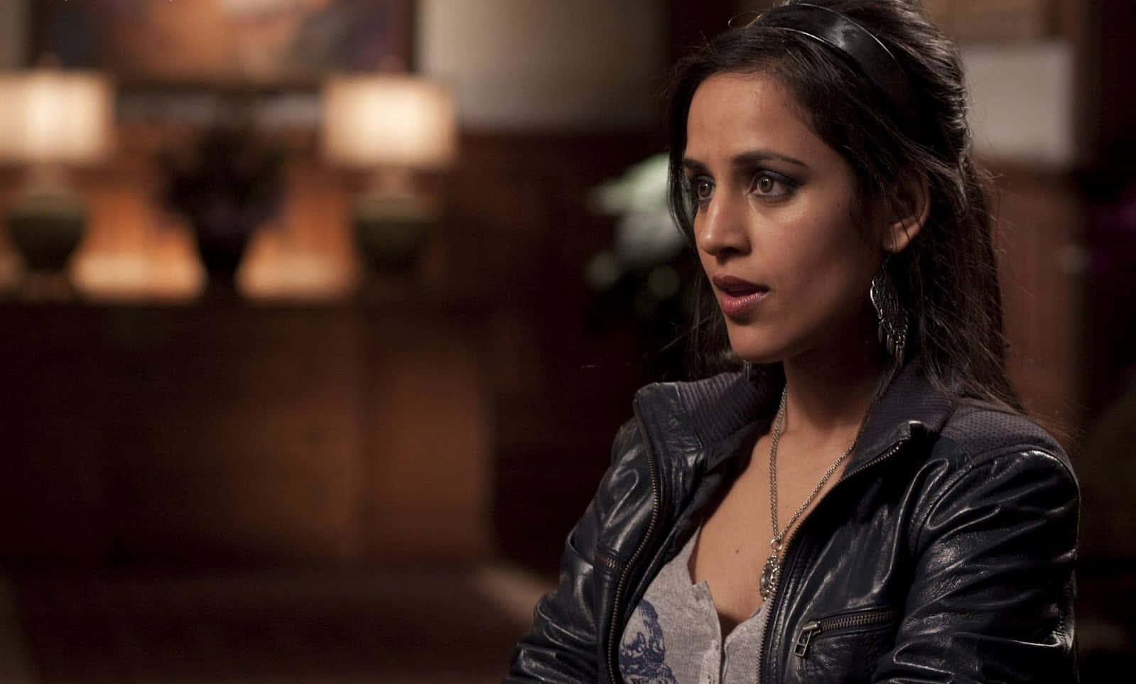 Agam Darshi, black leather jacket, warmly lit indoor setting, HD Desktop Wallpaper