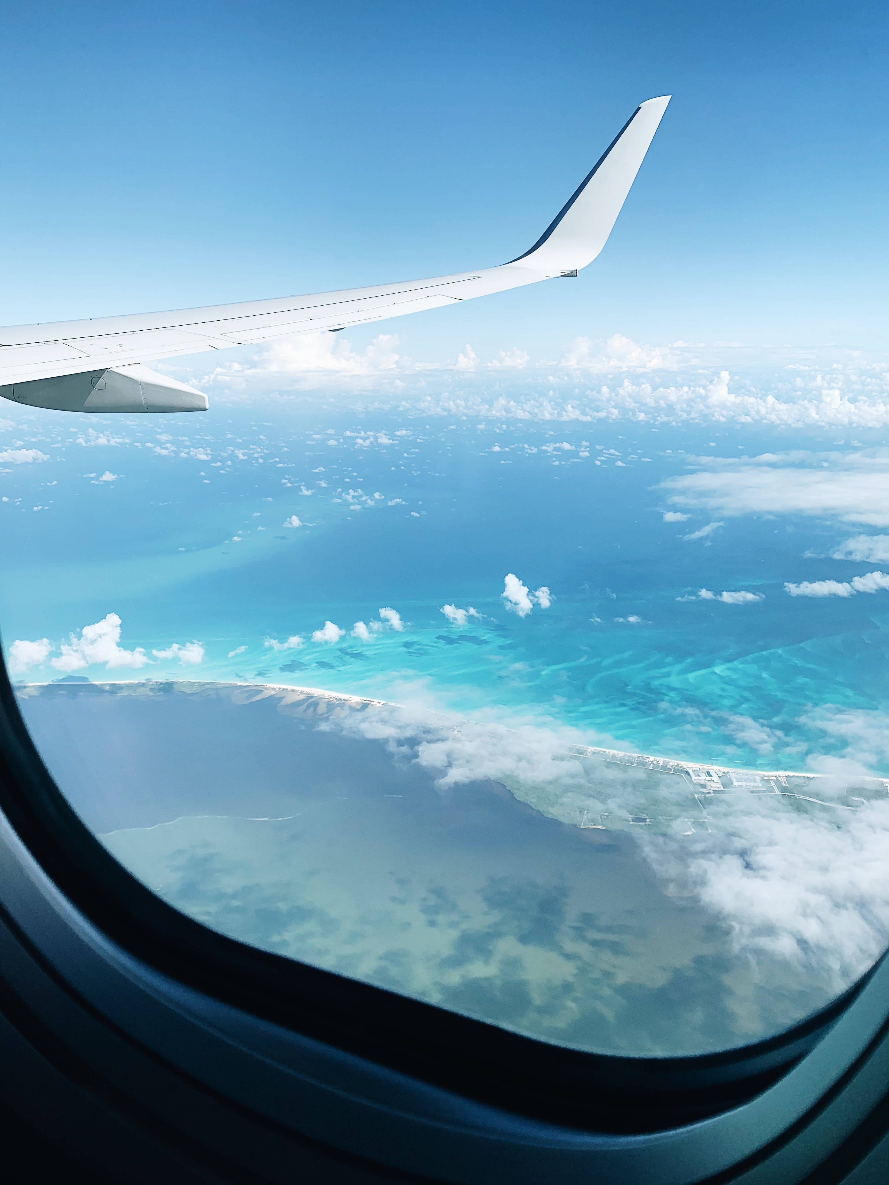 airplane window, turquoise ocean, white clouds, 4K Phone Wallpaper