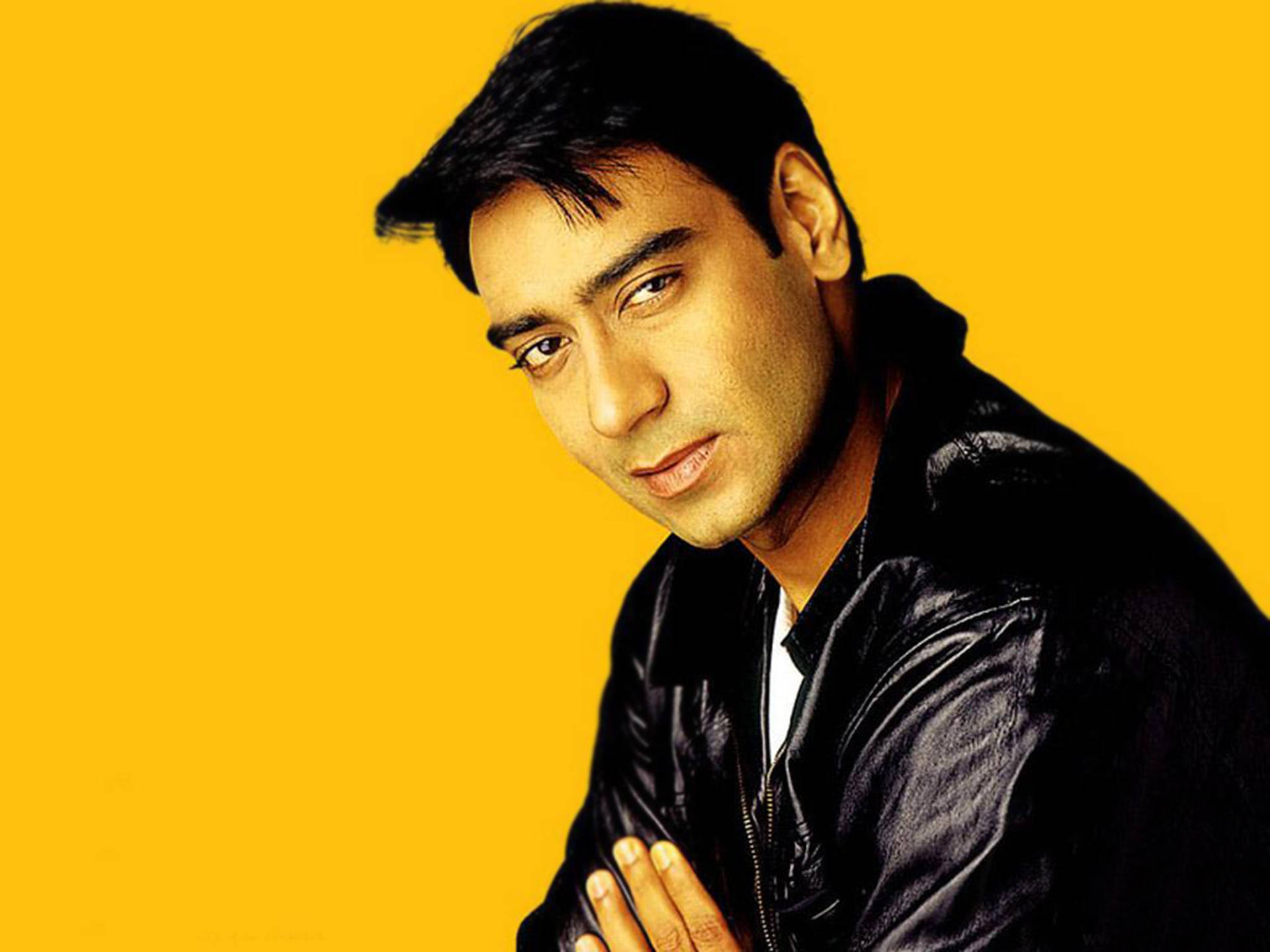 Ajay Devgn, black leather jacket, vibrant yellow background, Full HD Desktop Wallpaper
