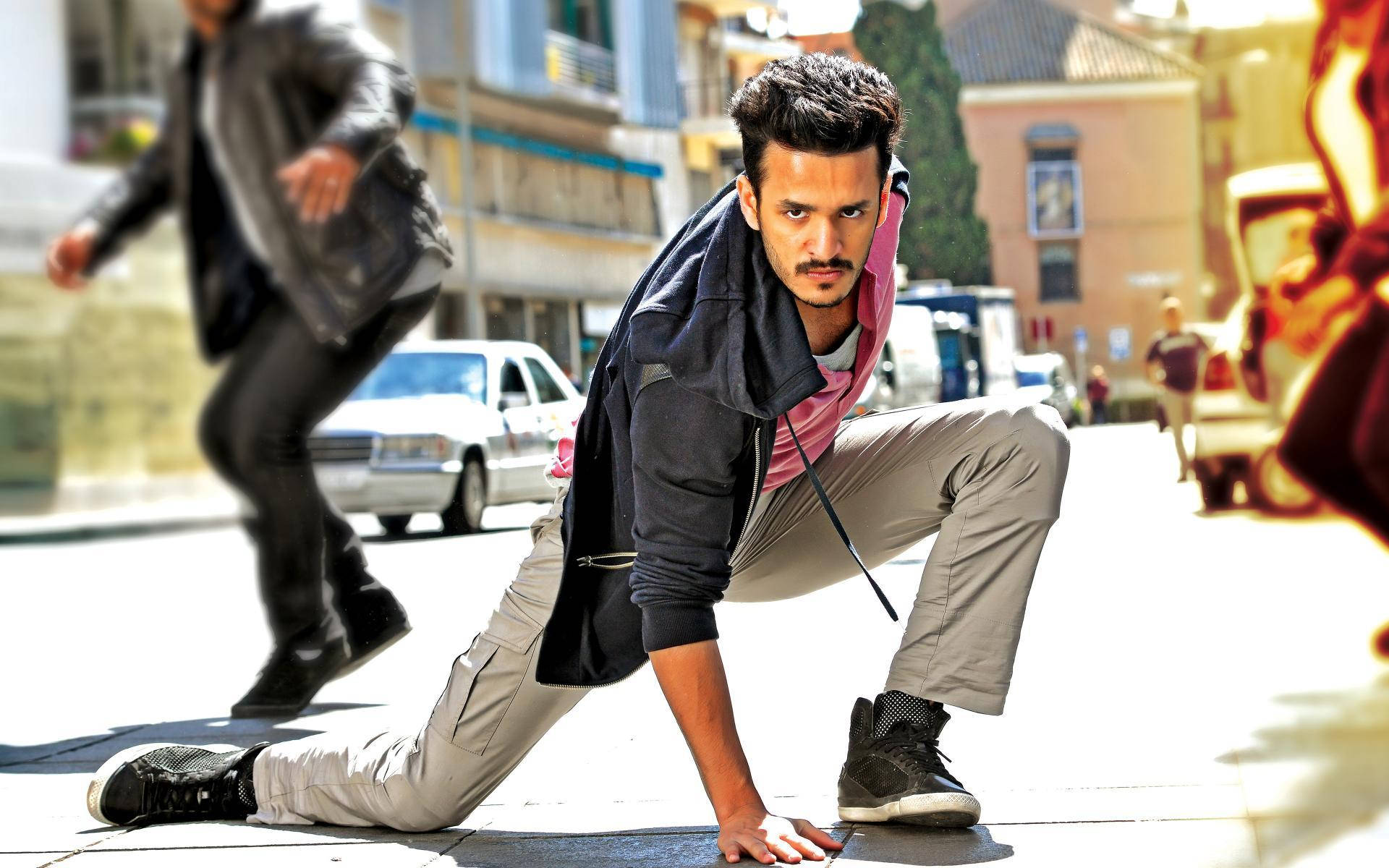 Akhil Akkineni, crouched pose, sunlit urban street, Full HD Desktop Wallpaper