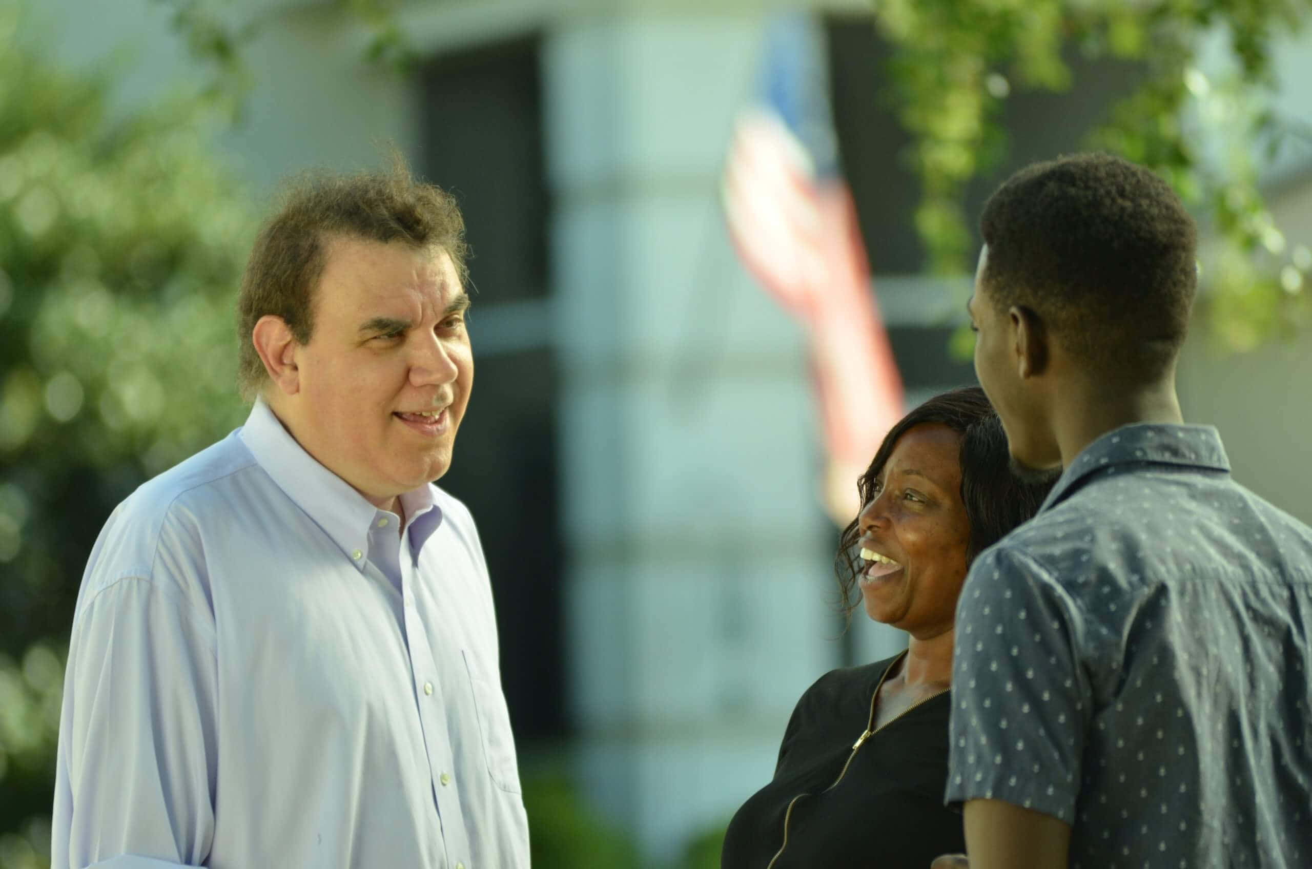 Alan Grayson, trees, blurred flag, 2K Desktop Wallpaper