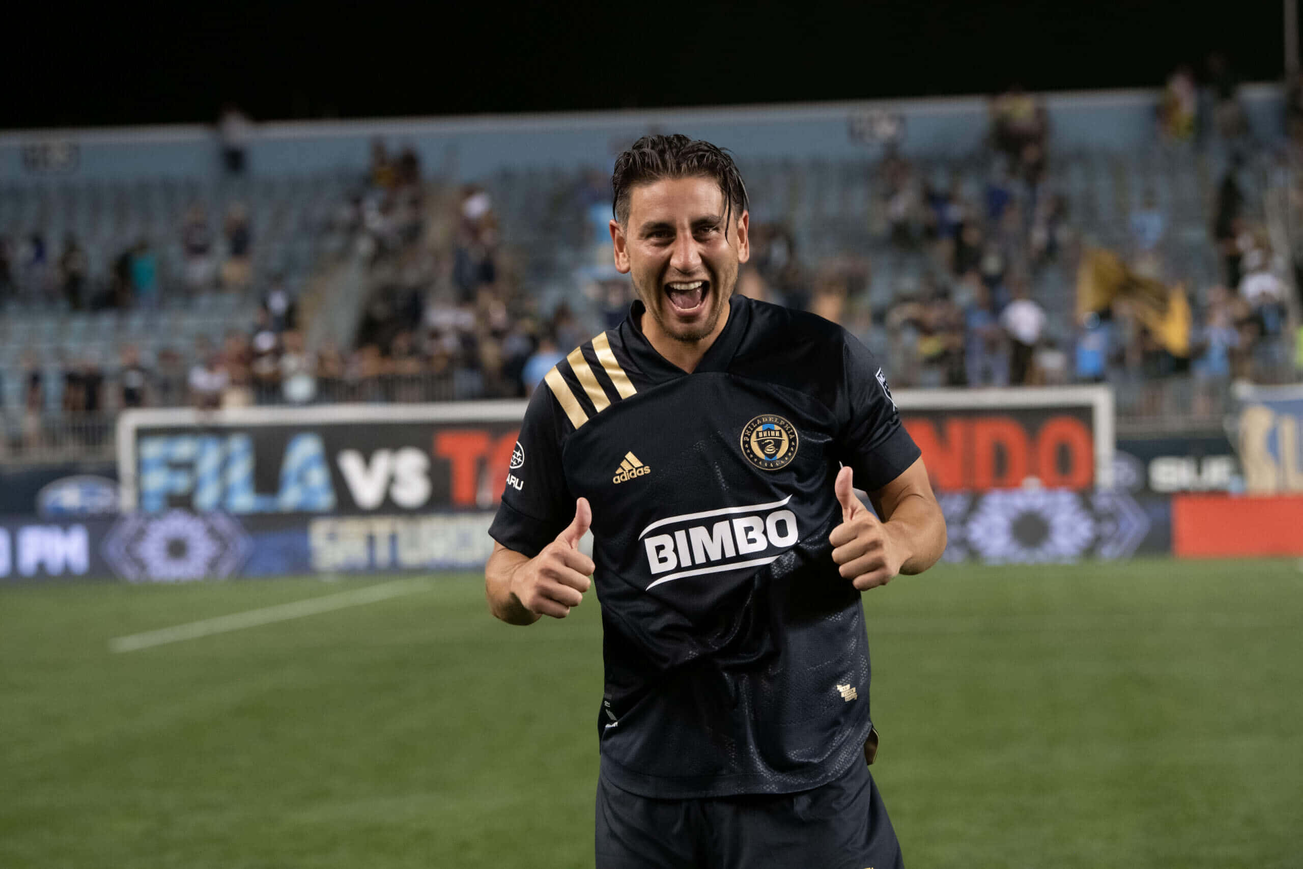 Alejandro Bedoya, black jersey, stadium field, 2K Desktop Wallpaper