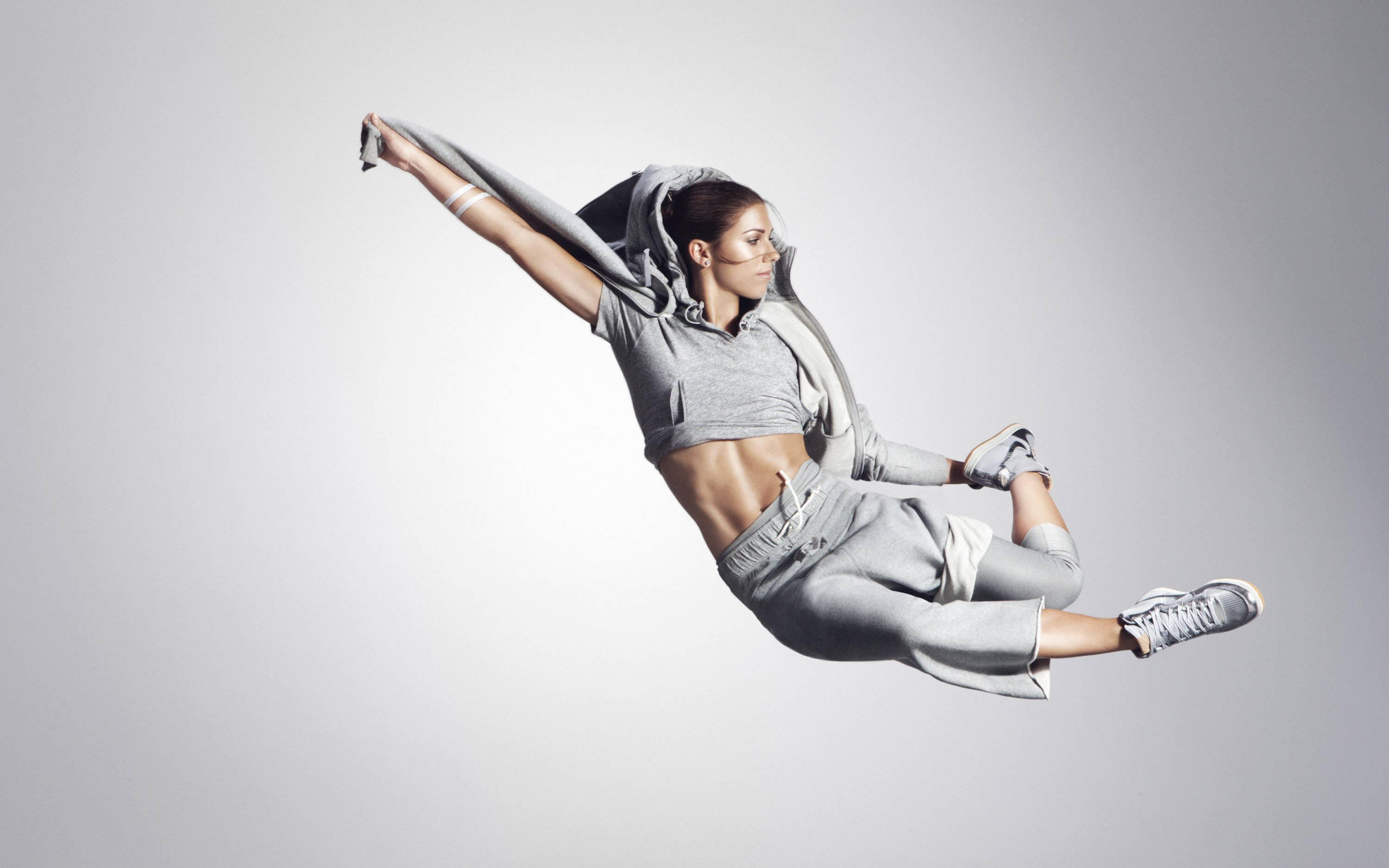 Alex Morgan, gray athletic wear, plain gray studio background, 2K Desktop Wallpaper