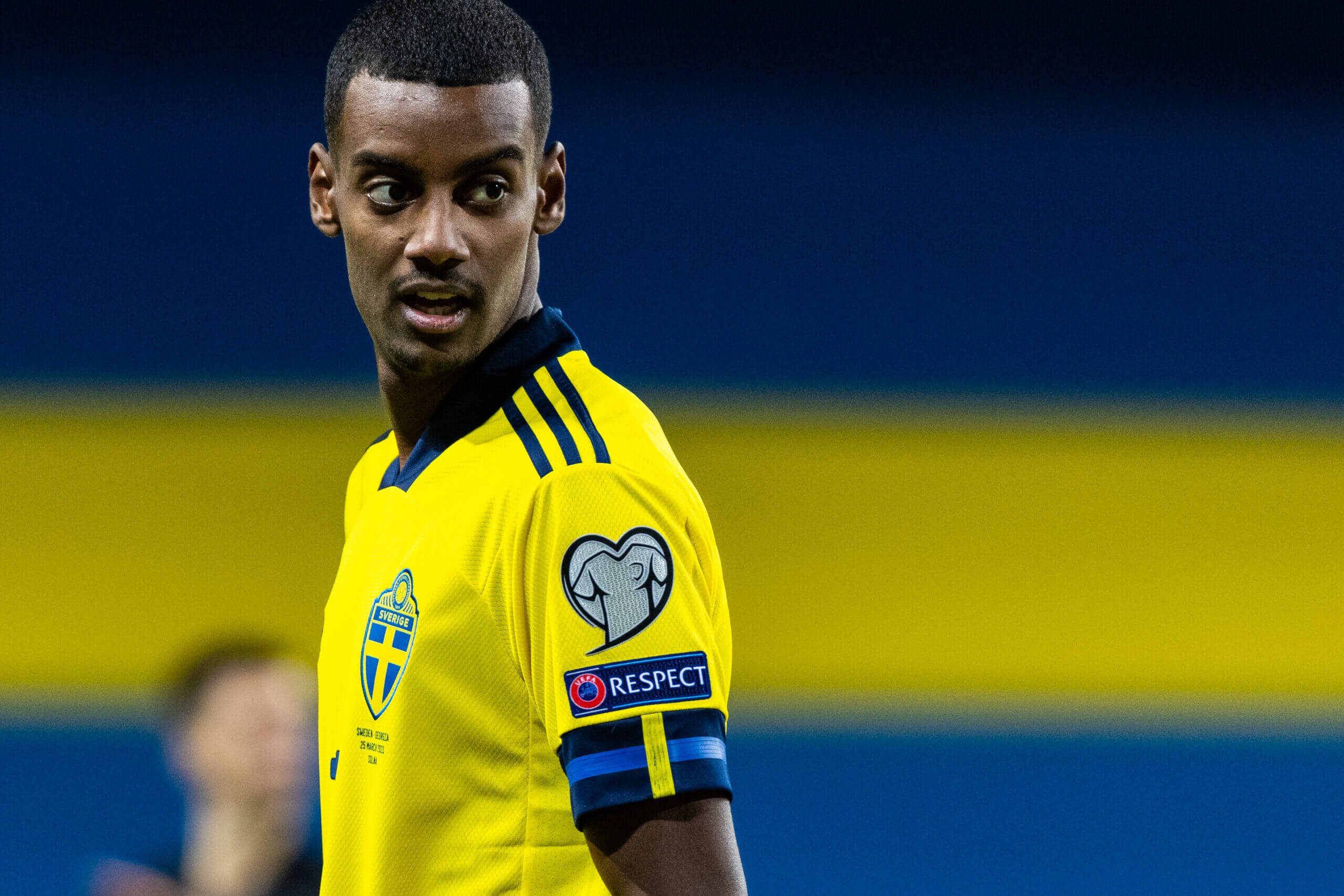 Alexander Isak, bright yellow Sweden jersey, blue and yellow stadium backdrop, 2K Desktop Wallpaper