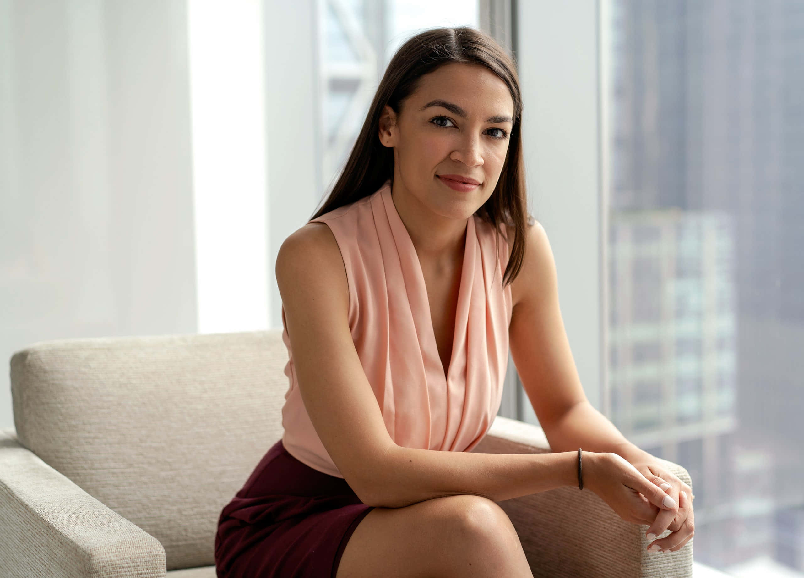 Alexandria Ocasio-cortez, peach top, maroon skirt, 2K Desktop Wallpaper