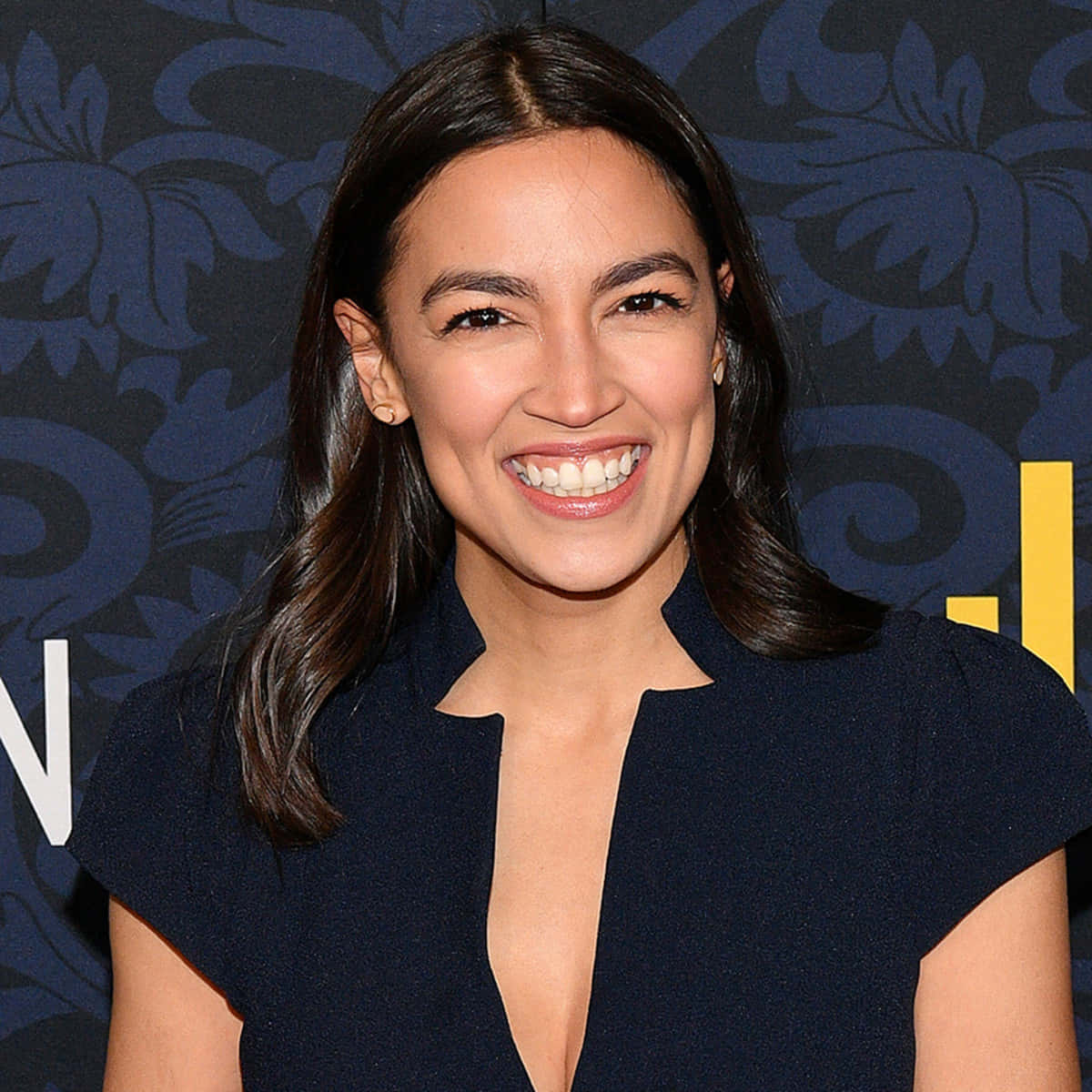 Alexandria Ocasio-cortez, navy dress, blue backdrop, SD Desktop Wallpaper