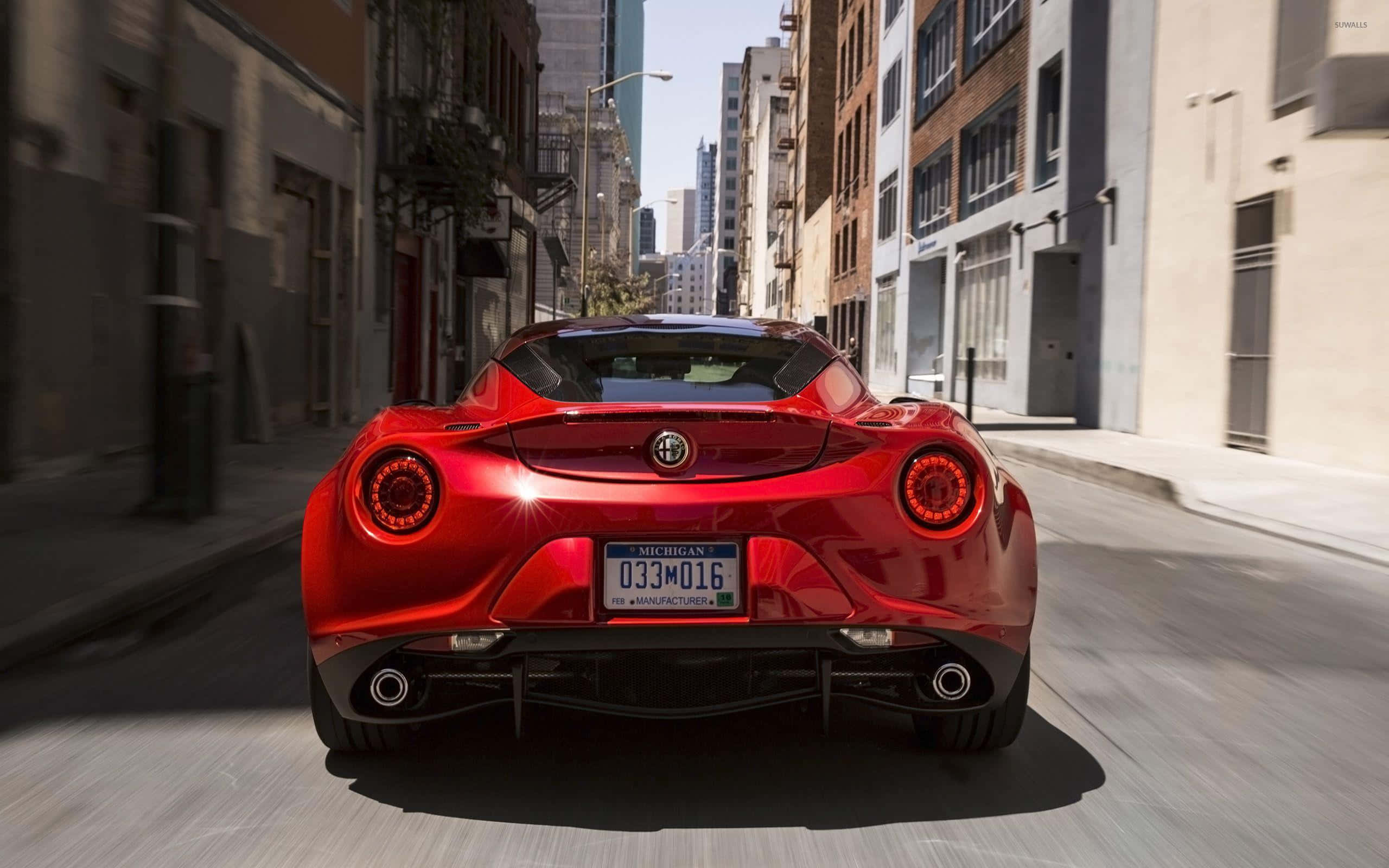 Alfa Romeo 4C, vibrant red, sunlit urban street, 2K Desktop Wallpaper