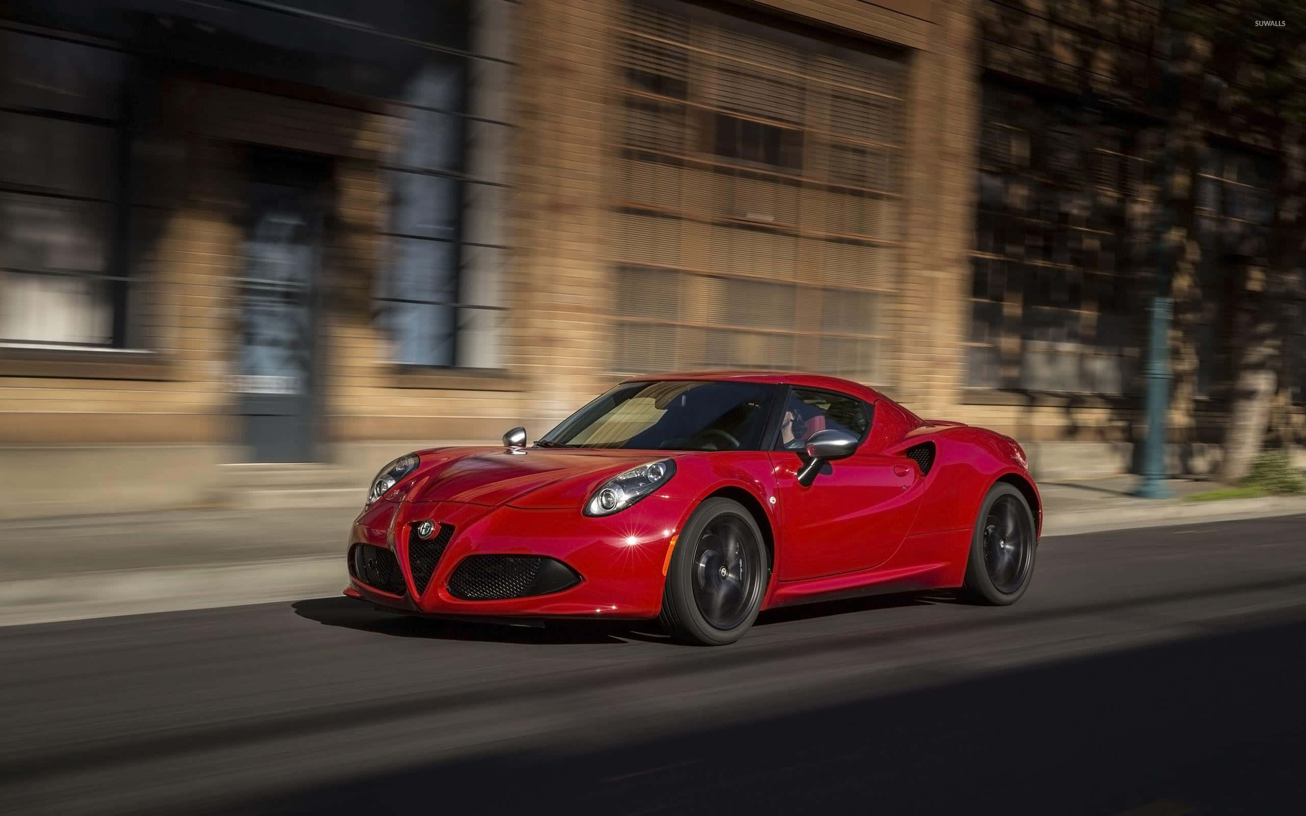 Alfa Romeo 4C, vibrant red, sunlit urban street, 2K Desktop Wallpaper
