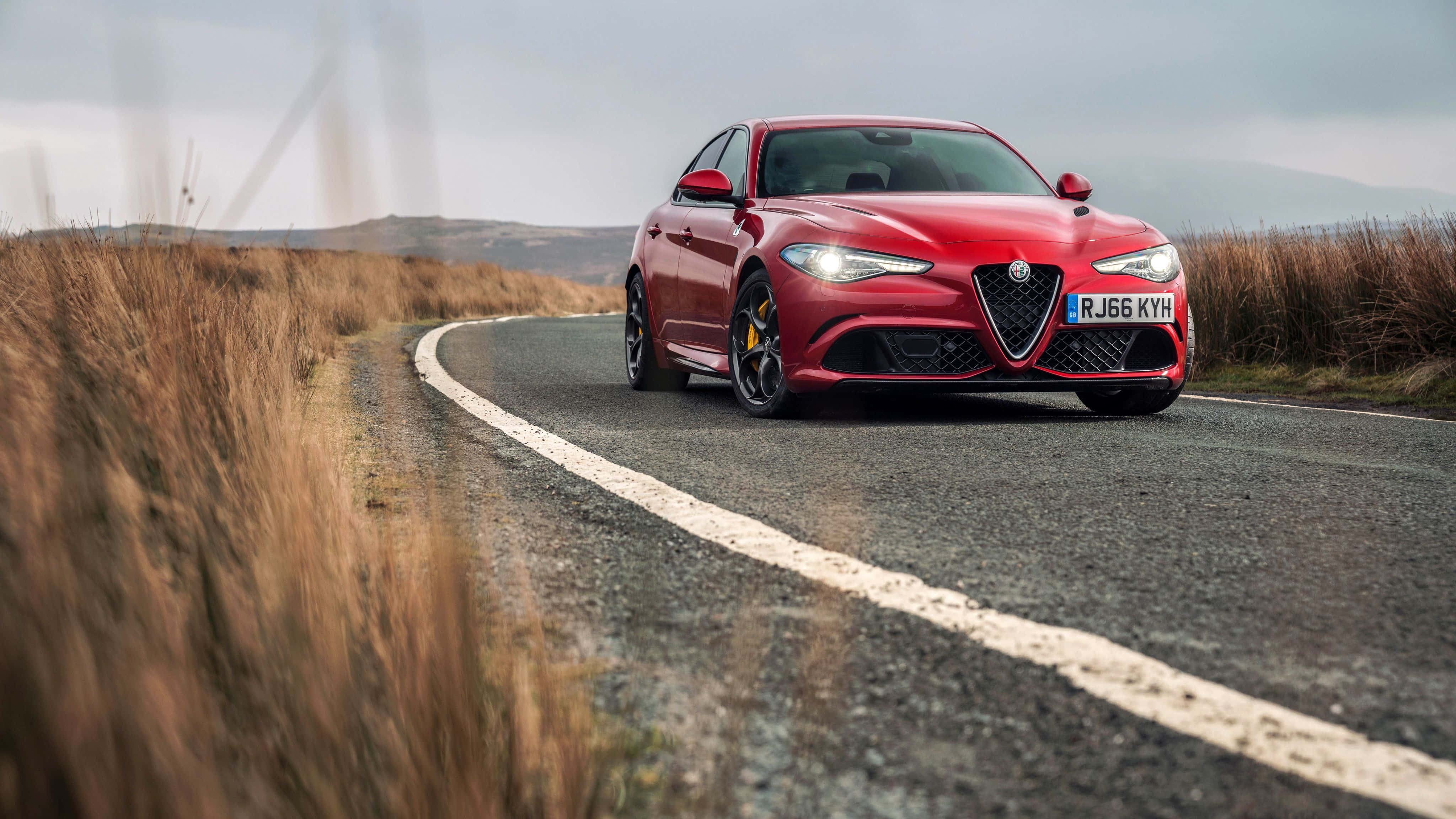 Alfa Romeo Giulia, vibrant red, winding rural road, 4K Desktop Wallpaper