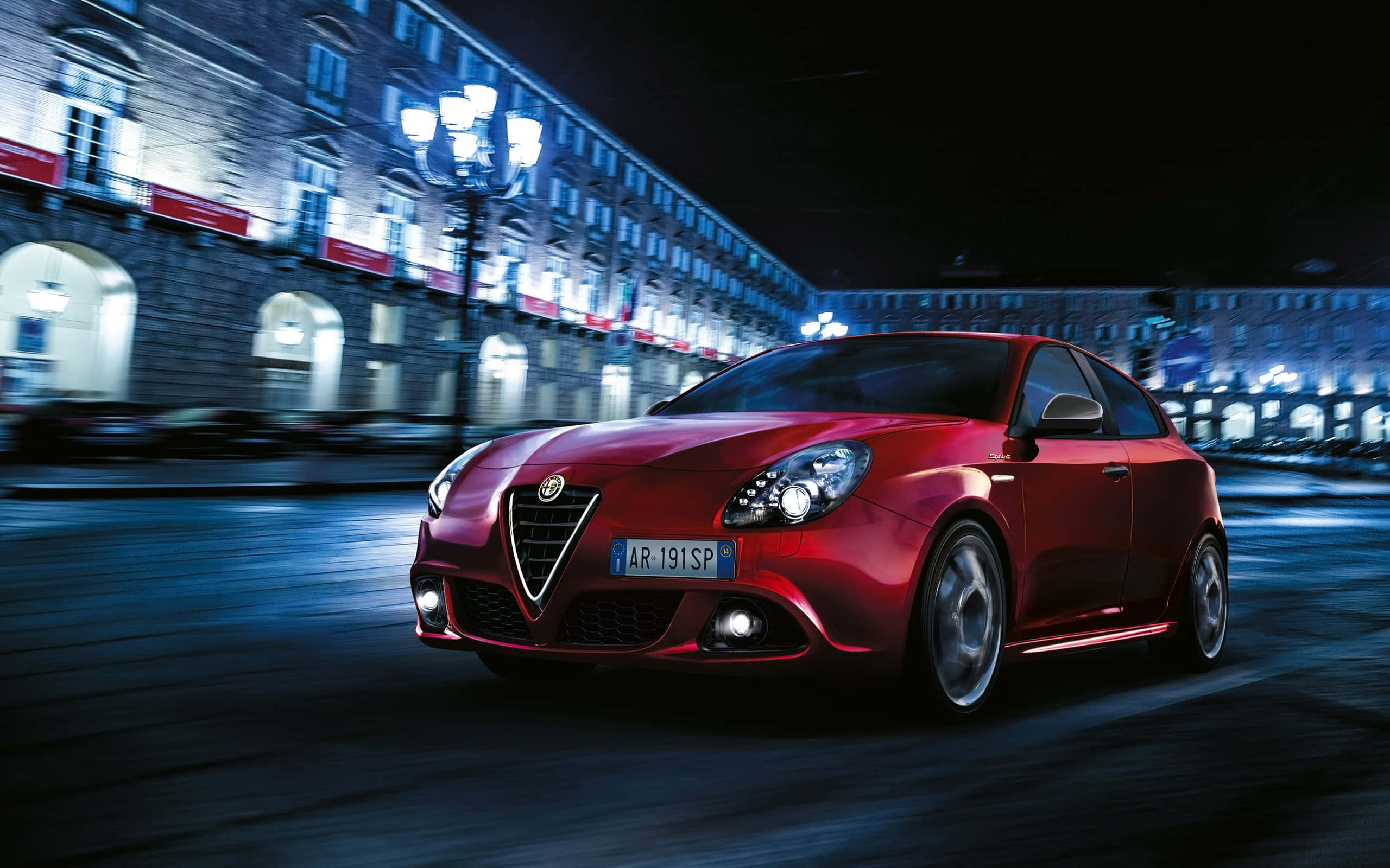 Alfa Romeo Giulietta, vibrant red, nighttime city street, 2K Desktop Wallpaper