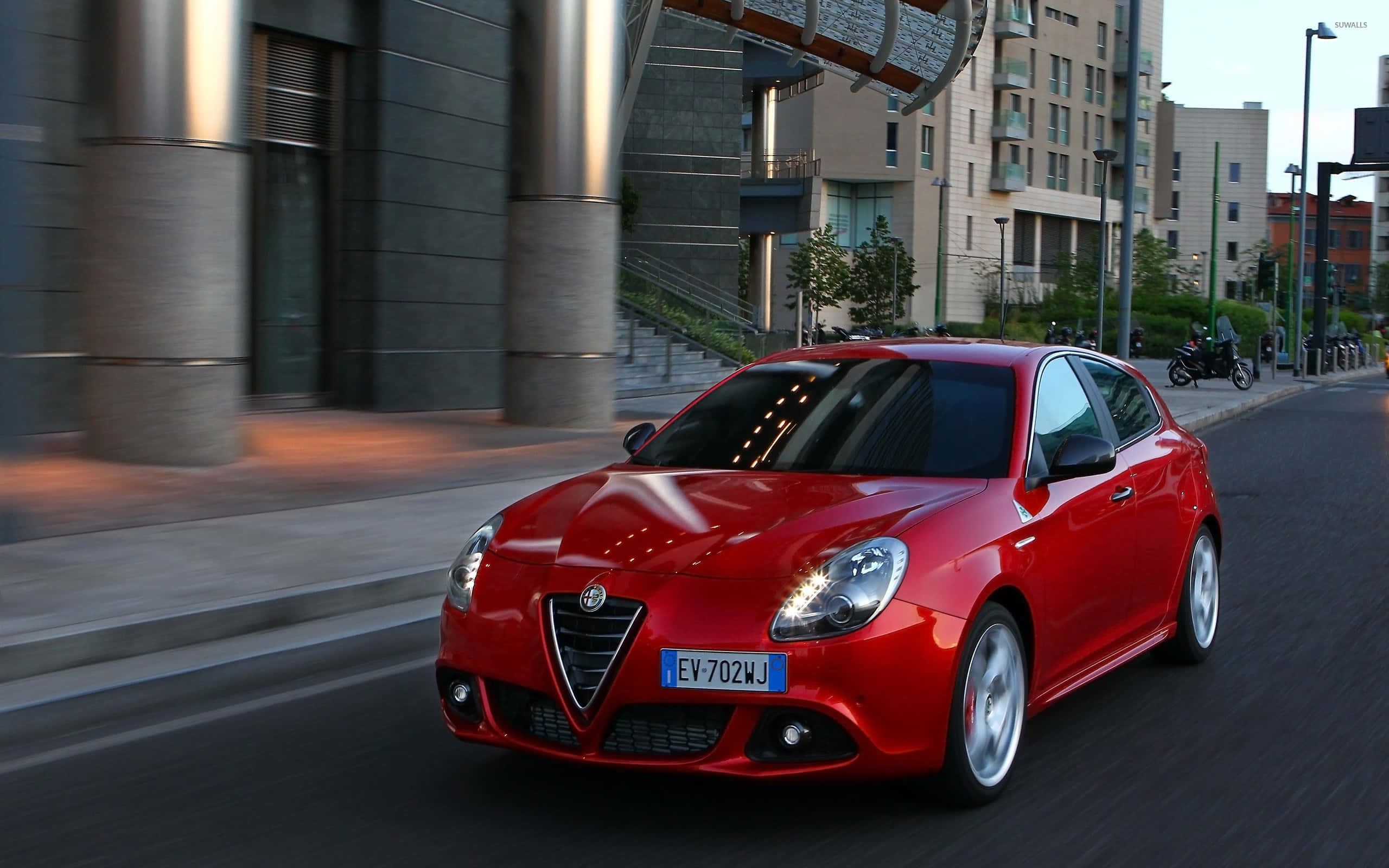 Alfa Romeo Giulietta, vibrant red, modern urban street, 2K Desktop Wallpaper