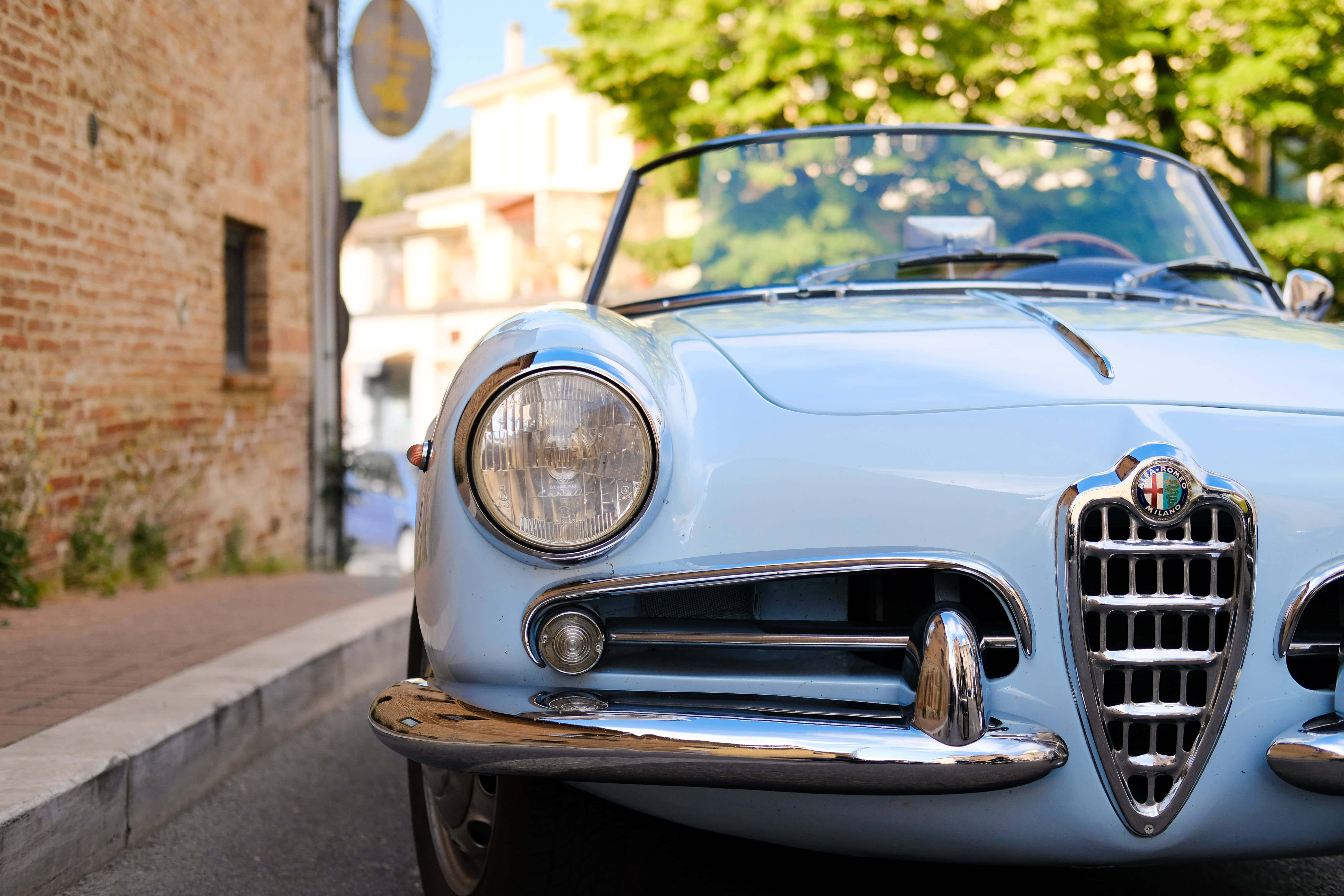 Alfa Romeo Spider, light blue, sunlit cobblestone street, 5K Desktop Wallpaper