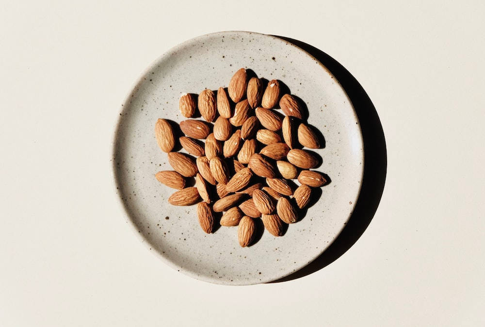 raw whole almonds, speckled ceramic plate, sharp shadow, SD Desktop Wallpaper